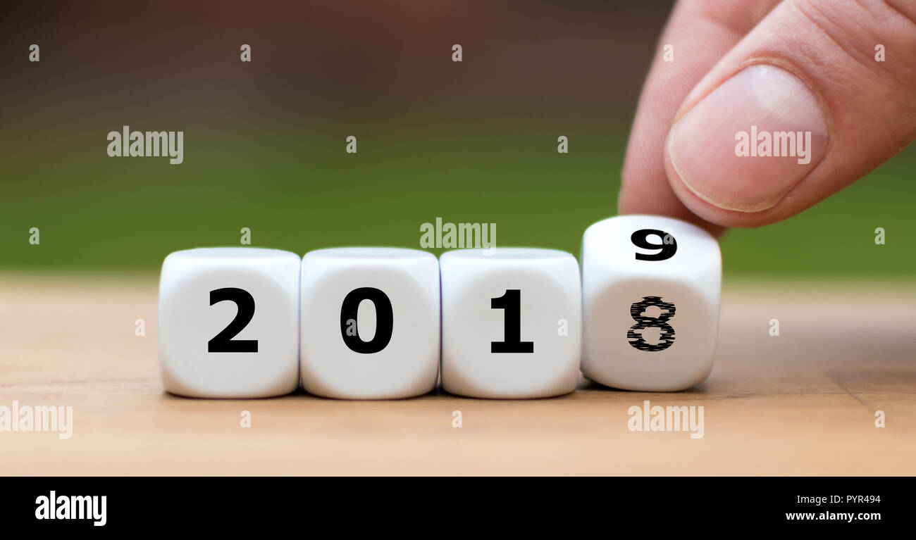 Hand is turning a dice and symbolically changes the year 2018 to 2019 Stock Photo