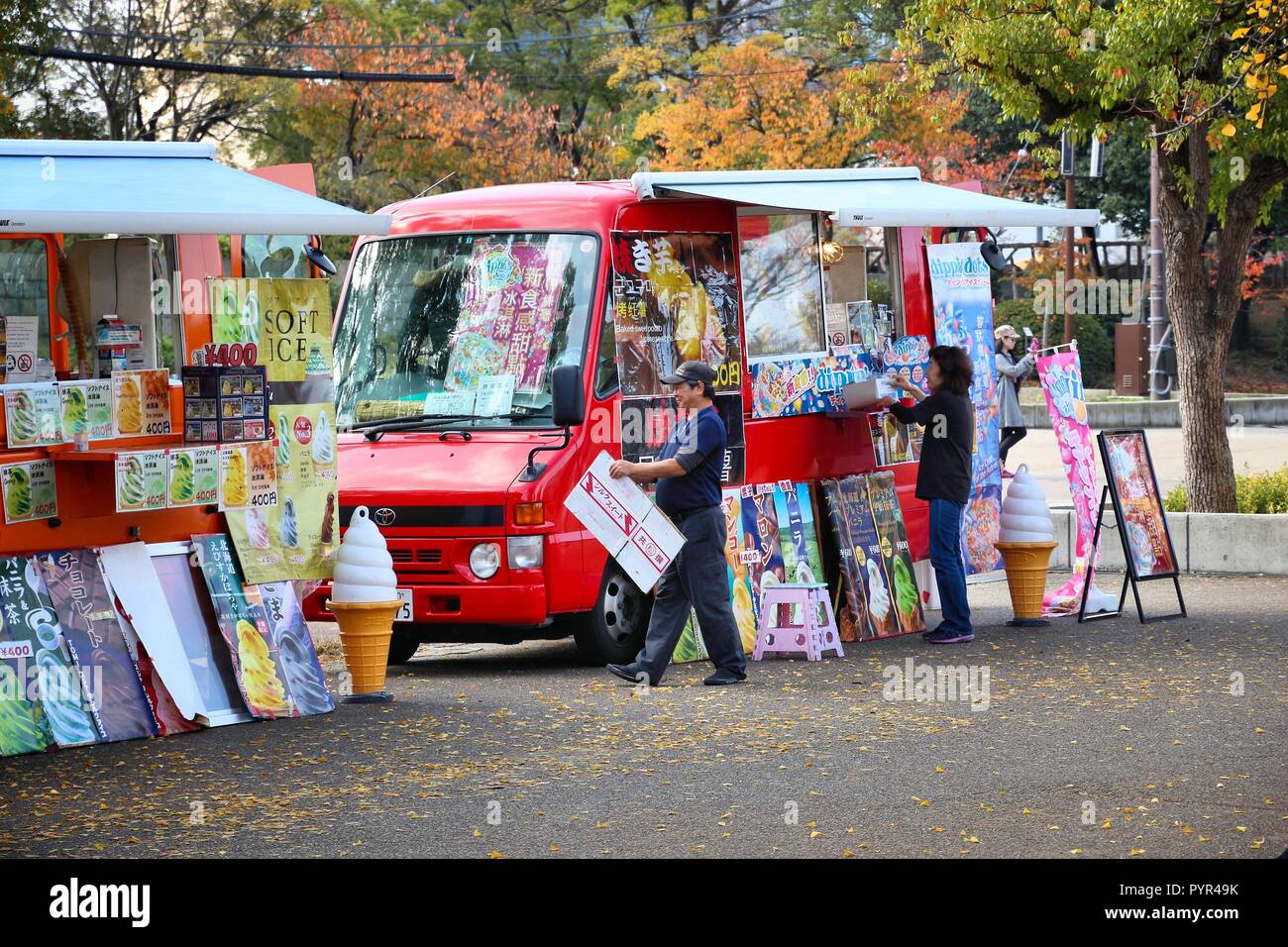 OSAKA, JAPAN - NOVEMBER 22, 2016: Owners prepare their ice cream truck in Osaka Castle Park, Japan. Food trucks are a popular and fashionable catering Stock Photo