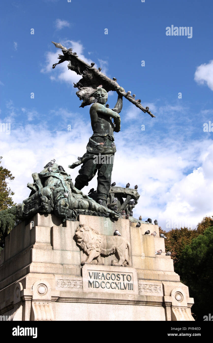 Realism style statue by Pasquale Rizzoli. Monument commemorating expulsion of Austrians from Bologna, Italy. Memorial covered in pigeons. Stock Photo