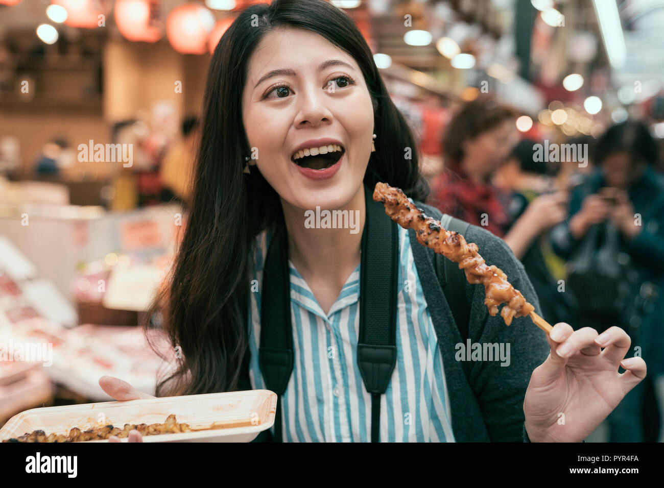 young lady tourist hobby eating local specialty street food in japan