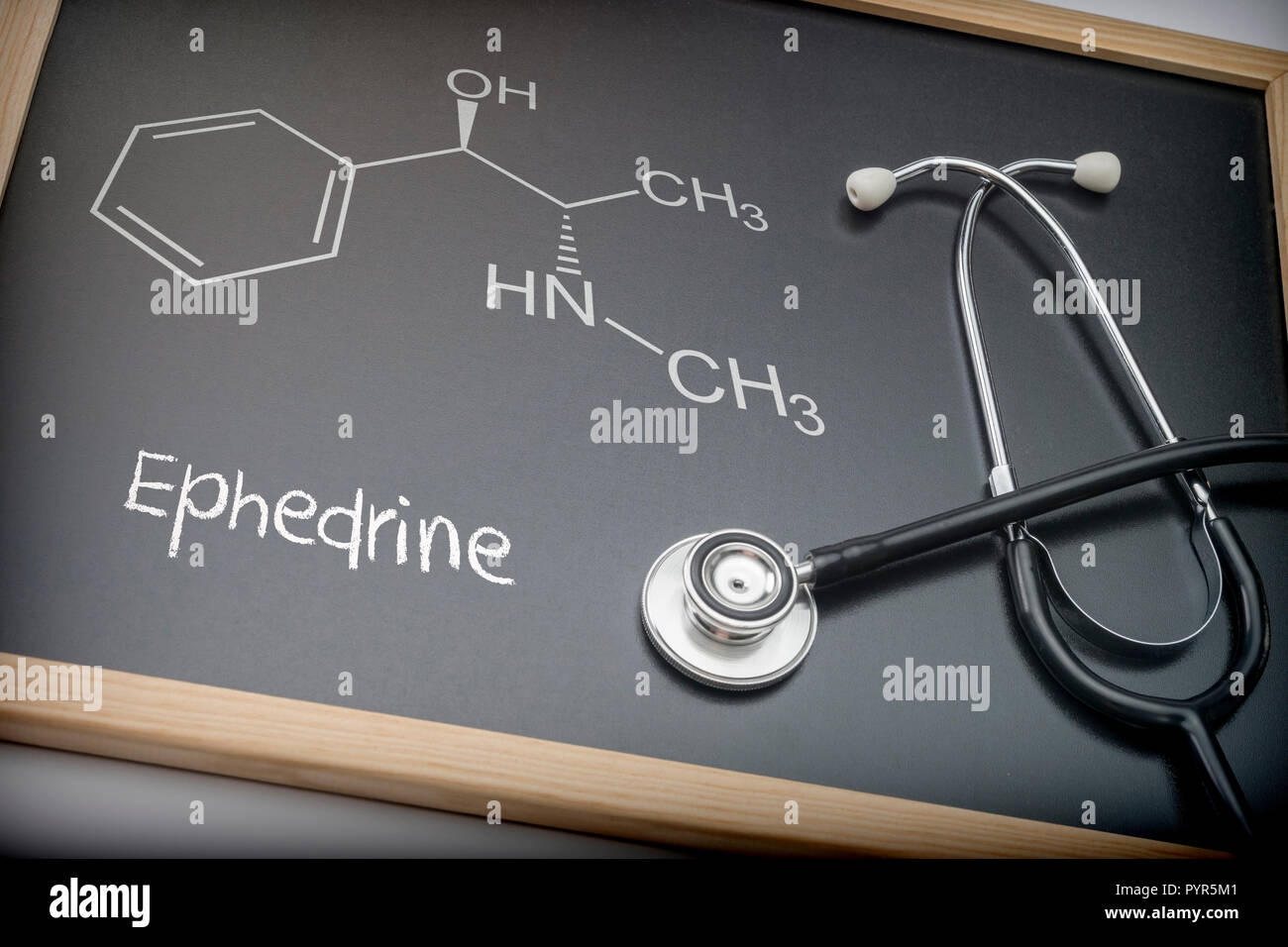 Word thyroid written in chalk on a blackboard black next to a stethoscope, conceptual image Stock Photo