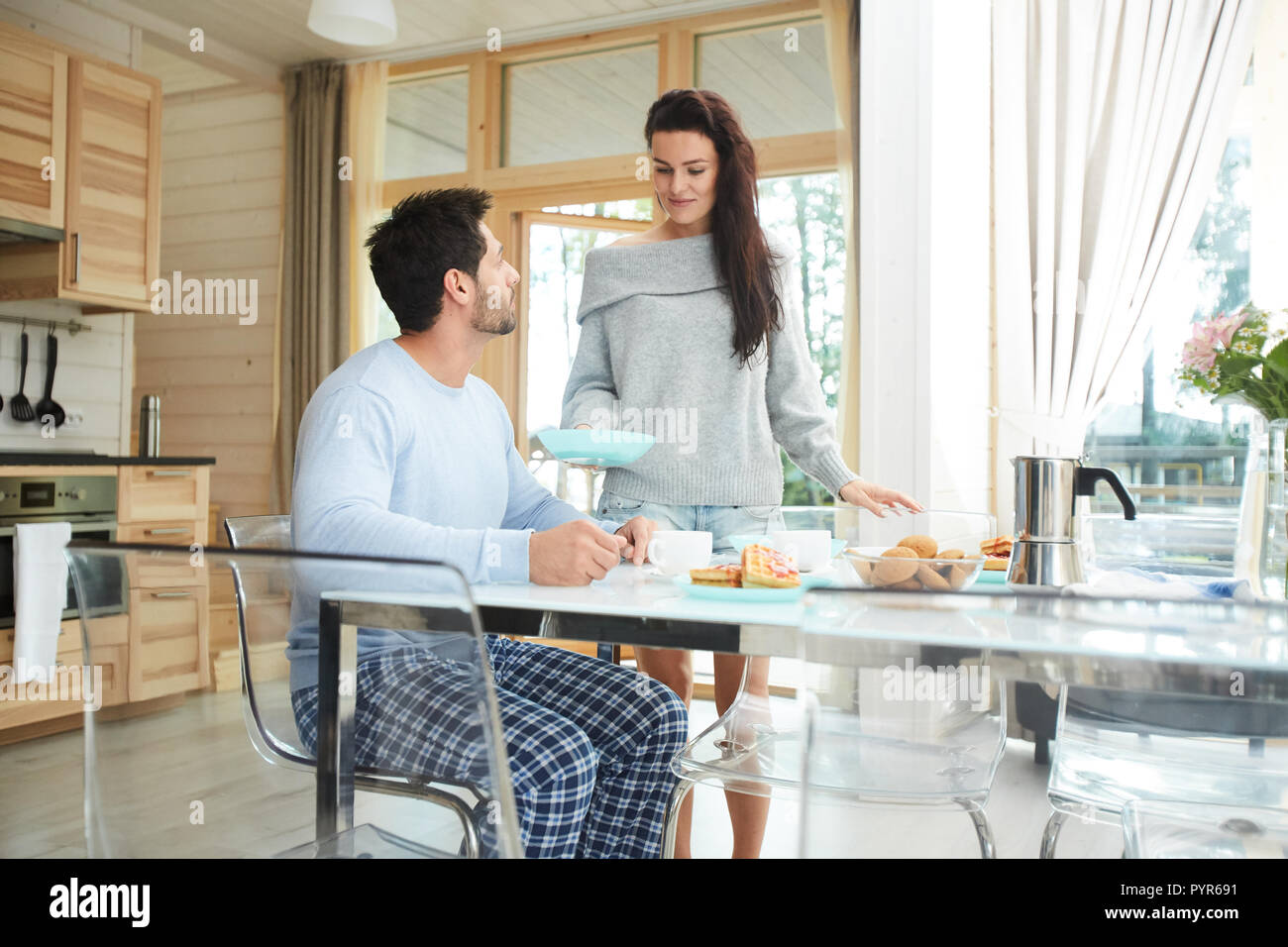 Careful young wife carrying breakfast to husband Stock Photo