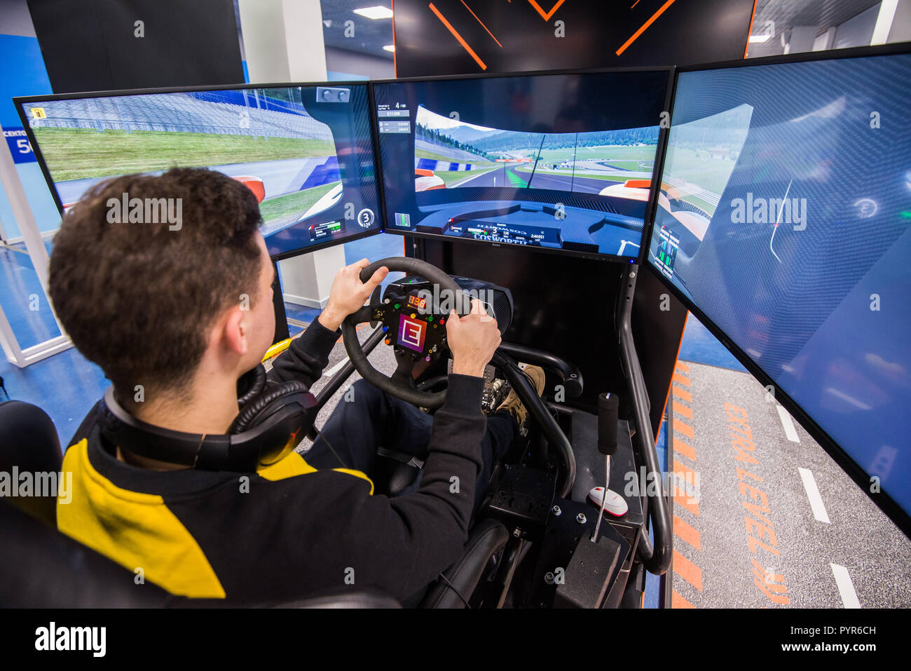 MOSCOW, RUSSIA - OCTOBER 27 2018. Simulation of race car video player game with big screen monitors and cockpit controls like a racing car. Stock Photo