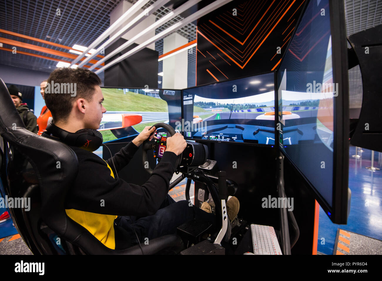 MOSCOW, RUSSIA - OCTOBER 27 2018. Simulation of race car video player game with big screen monitors and cockpit controls like a racing car. Stock Photo
