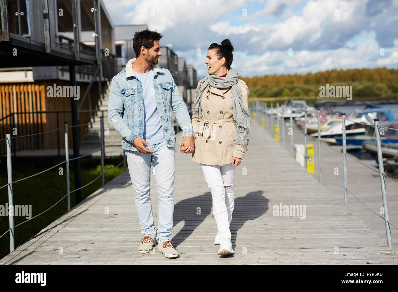 Excited young couple holding hands while walking together Stock Photo