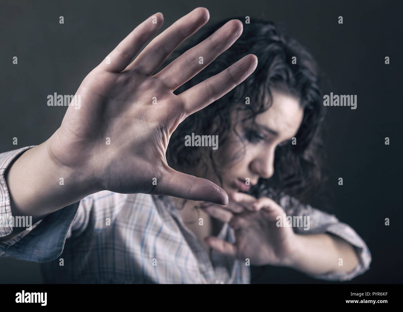 Beautiful woman victim of domestic violence and abuse. Focus on hand Stock Photo