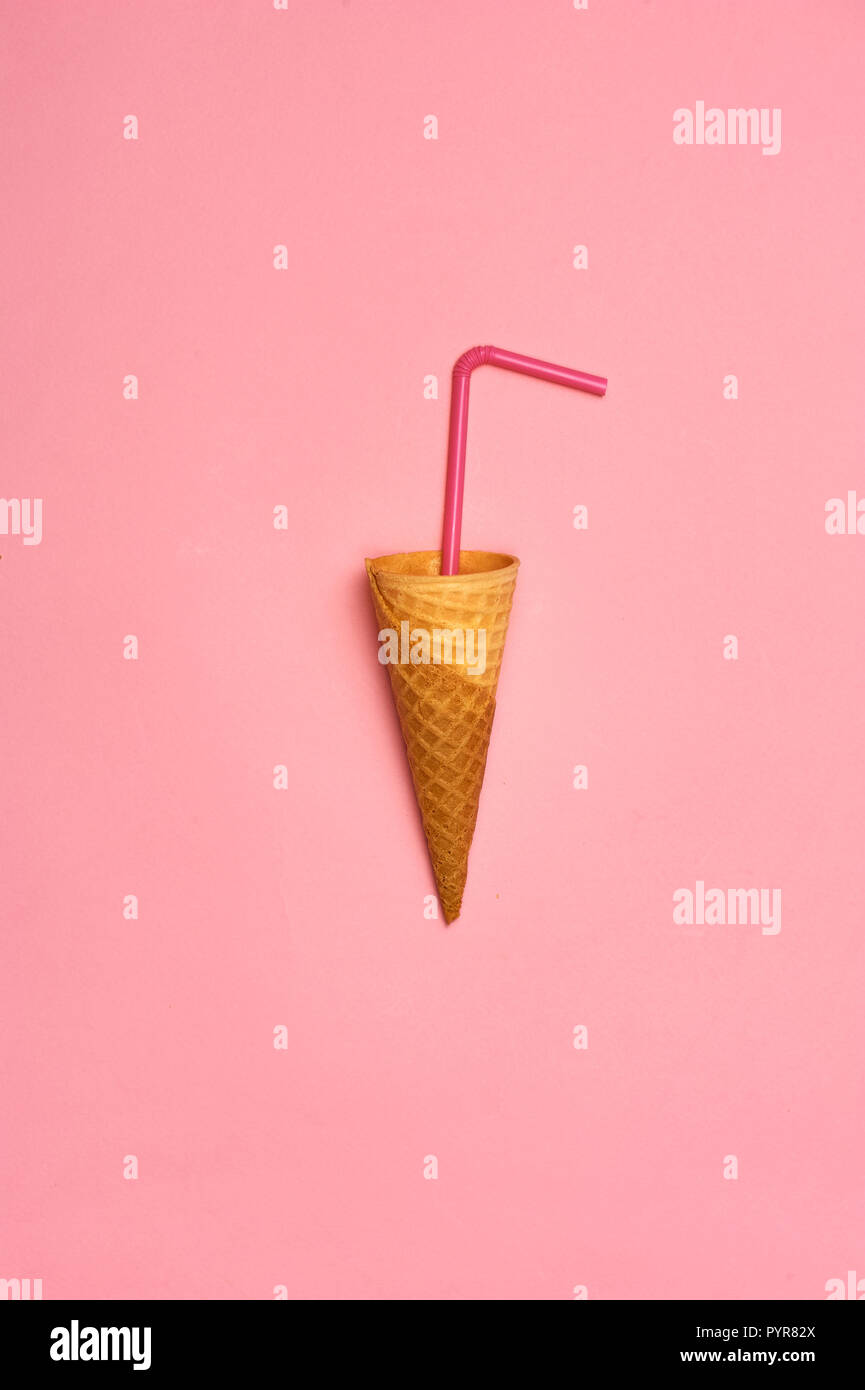 Empty ice cream cornet on pink background. Flat lay style. Stock Photo