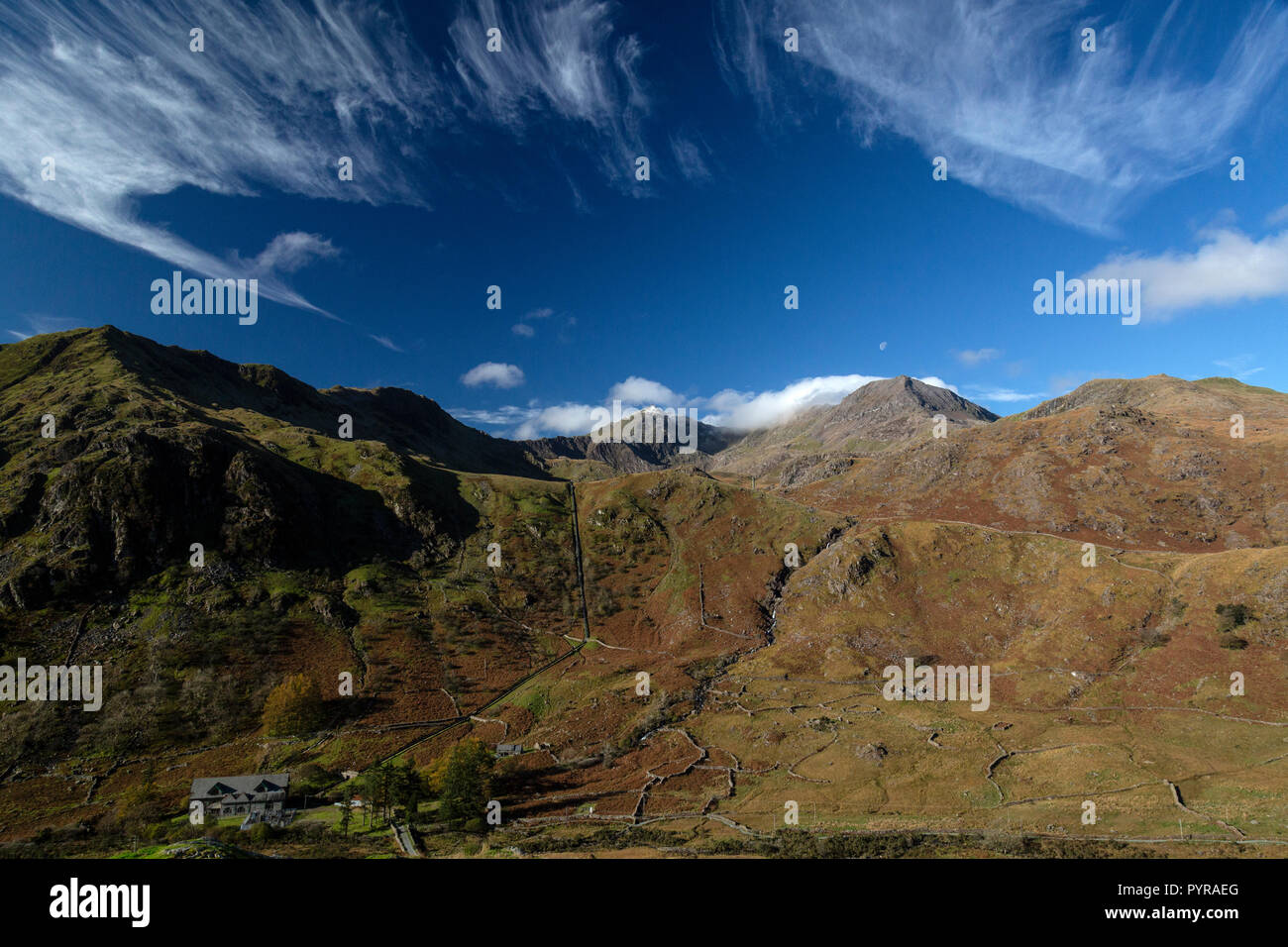 Snowdonia National Park in Wales. The snow capped peak of Mount Snowdon in the far distance, with the face of Y LLiwedd in shadow on the left. Stock Photo