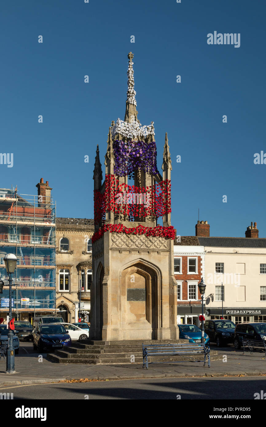 Knitted poppies in red, white and purple decorate Devizes Market Cross for Remembrance Day, Devizes, Wiltshire Stock Photo