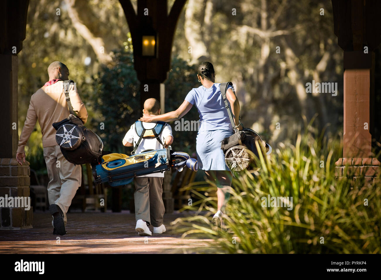 Family carrying golf bags Stock Photo