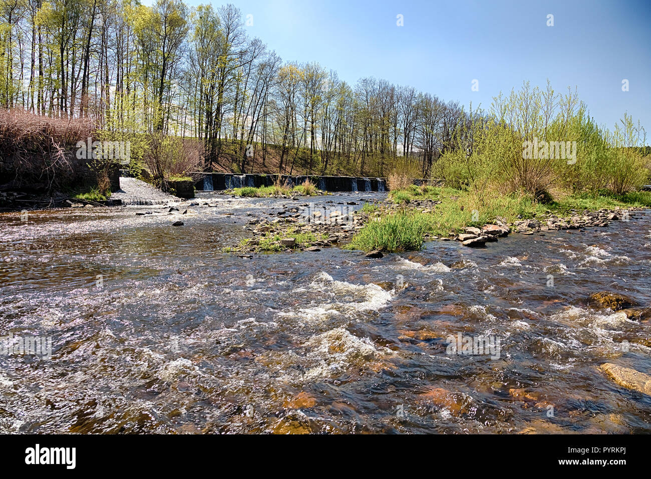 River with the weir runs over boulders Stock Photo