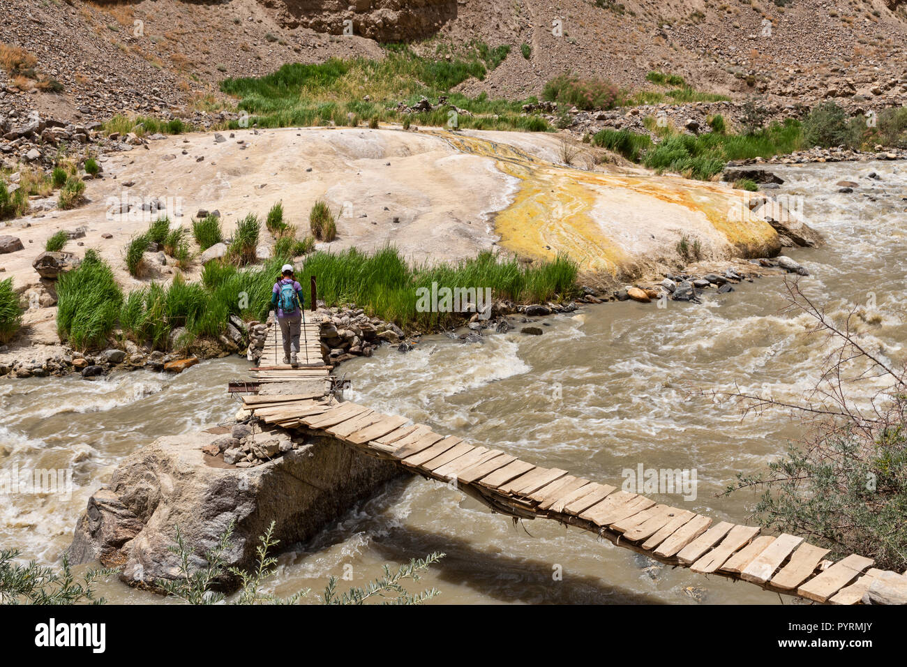 Trekker crosses Darshai gorge to access natural hot springs in Darshai Dara, Darshai, Wakhan Valley, Tajikistan Stock Photo