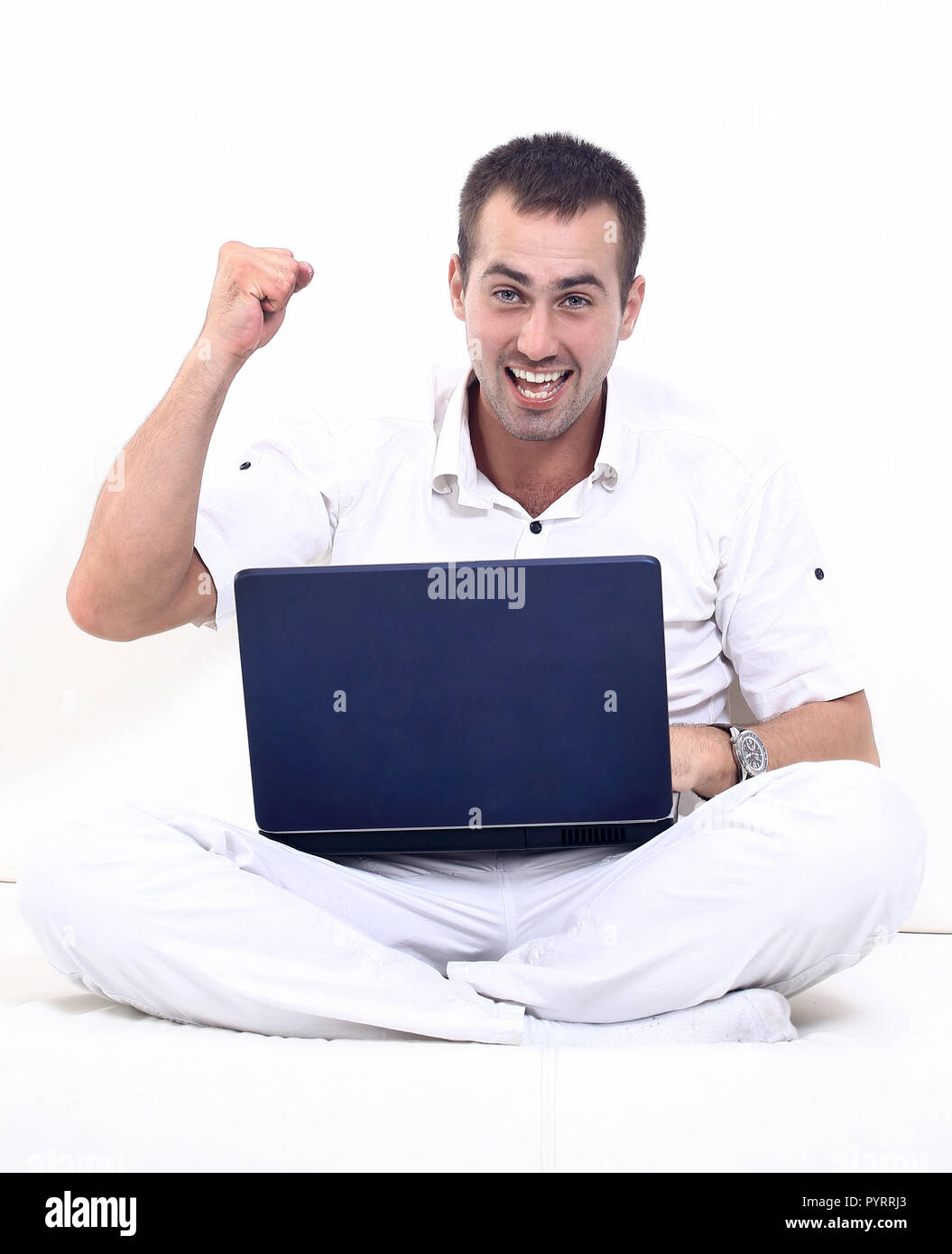 happy man working on laptop, sitting on the couch. Stock Photo