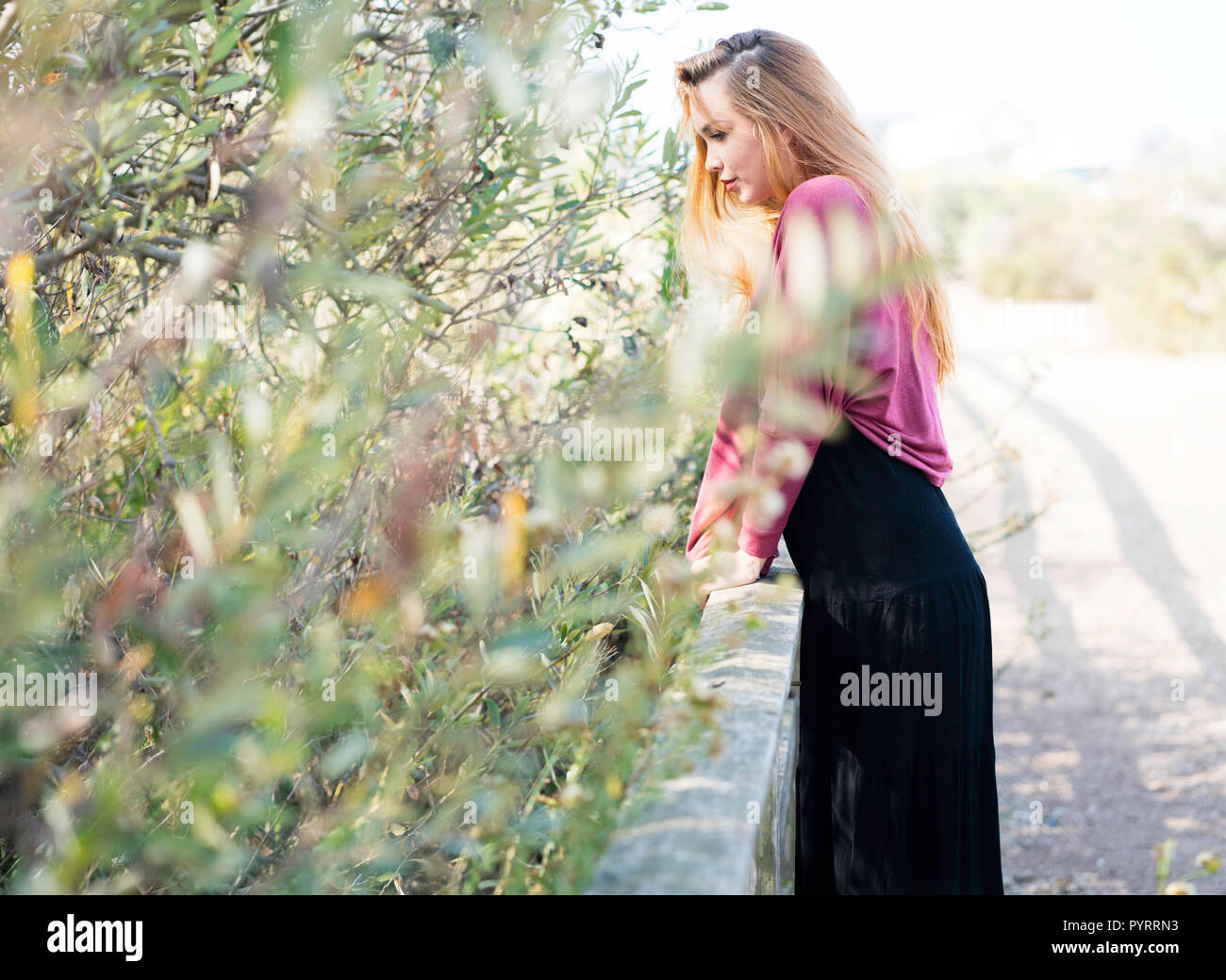 A young model poses outdoors in a 