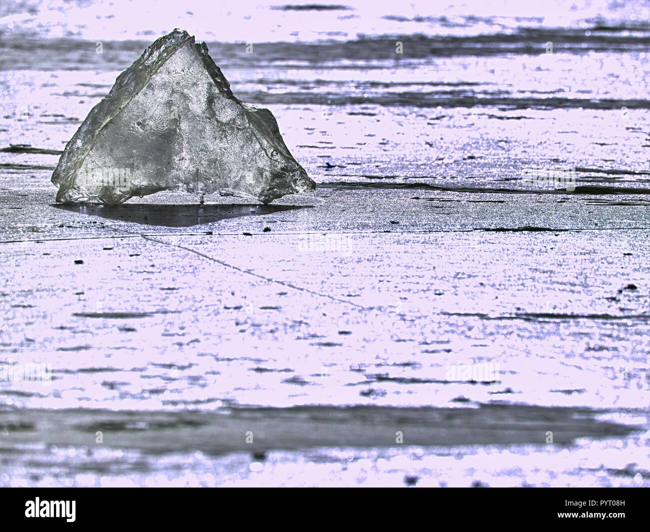 Iceberg piece in the snow floe floating in open ocean. Pink sunset sky in the background. Stock Photo