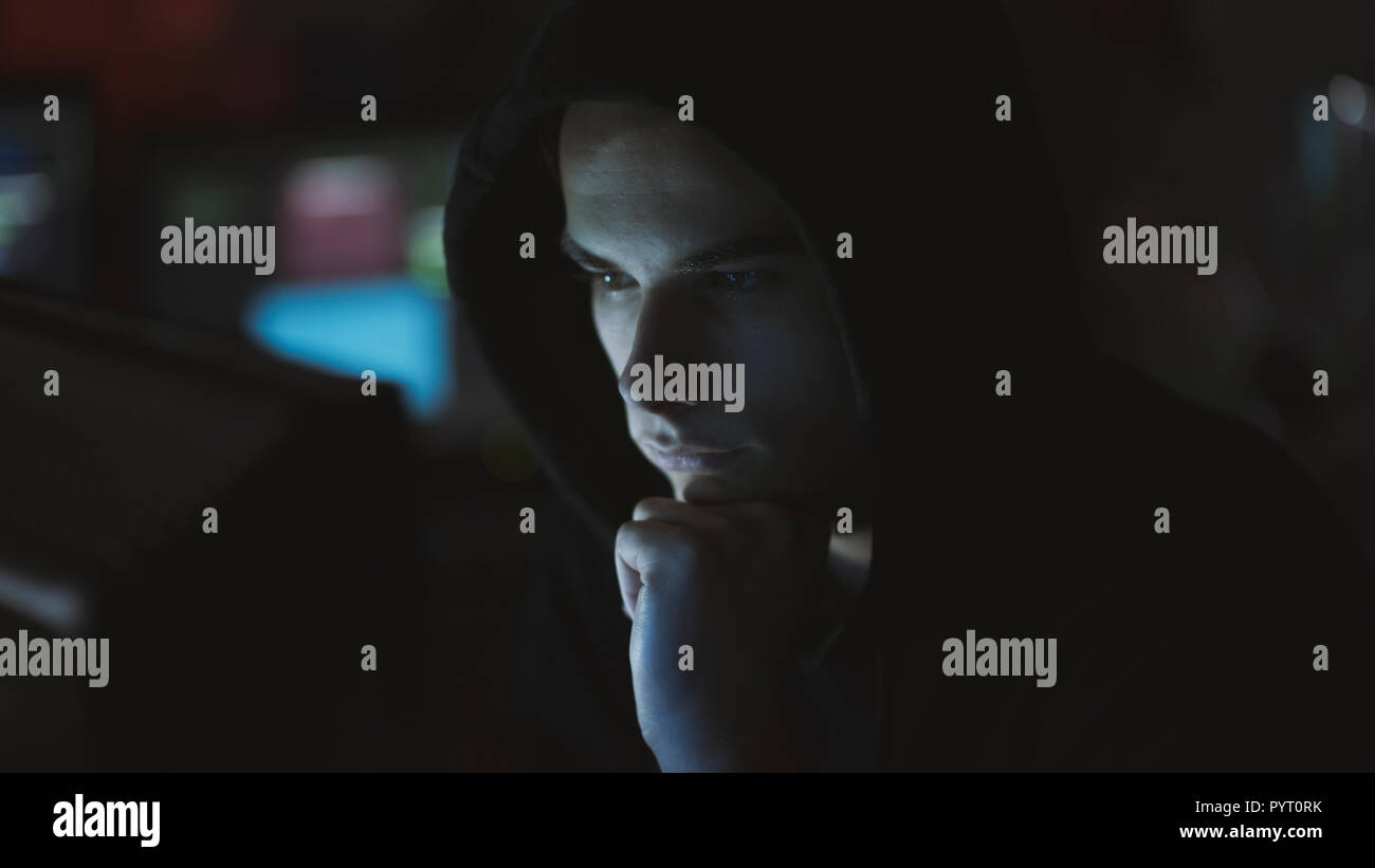 Young professional hacker working in a dark office with computers, cyber security and hacking concept Stock Photo