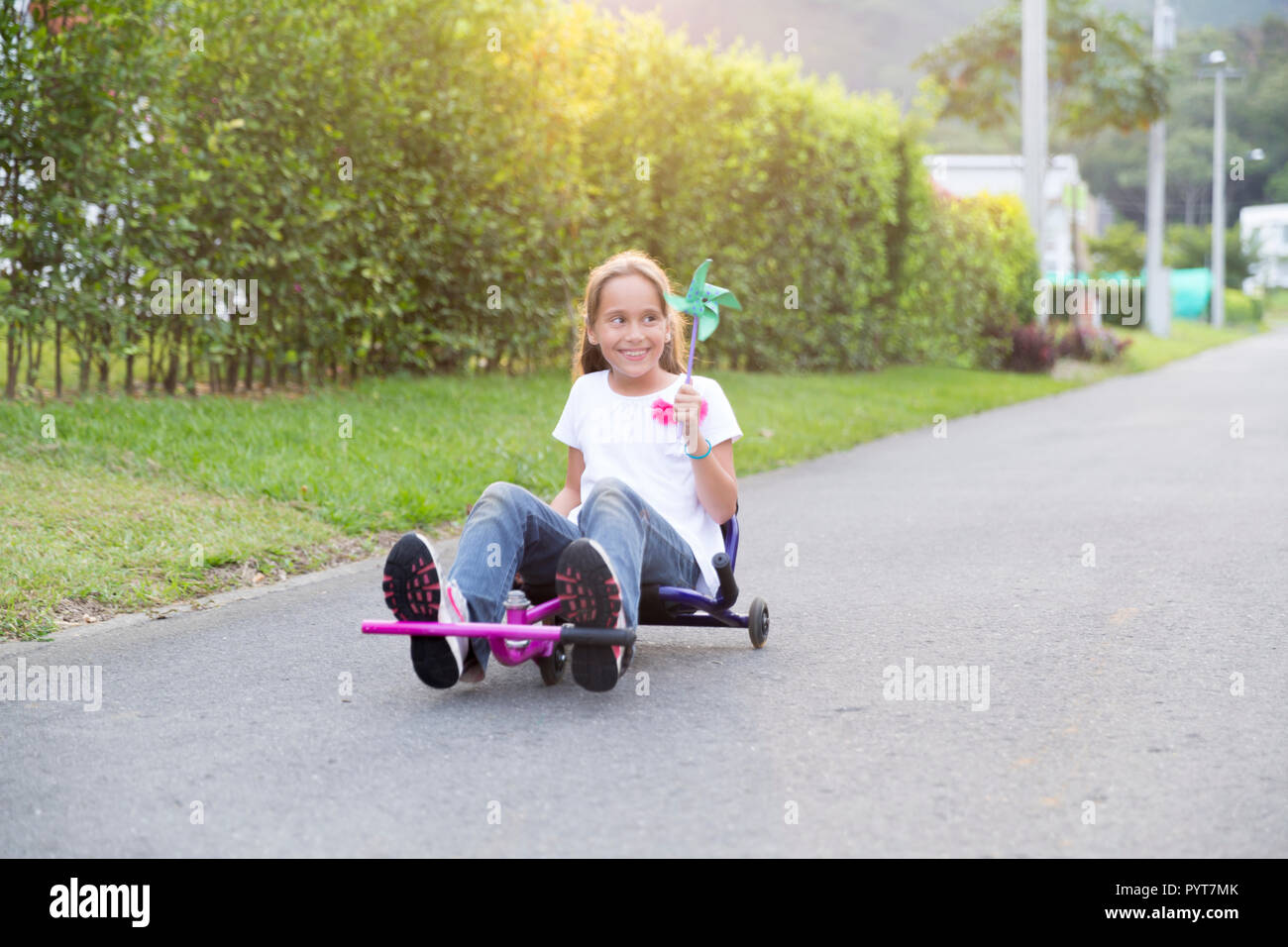 Happy Little Girl Driving Her Toy In The Park Stock Photo - Alamy