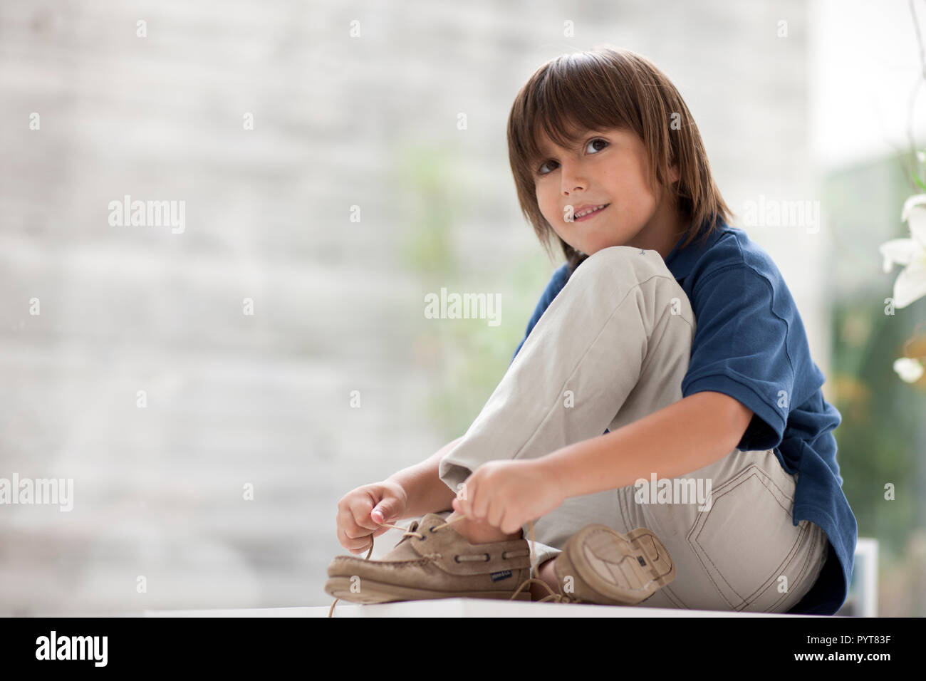 Young boy ties his shoelaces Stock Photo - Alamy
