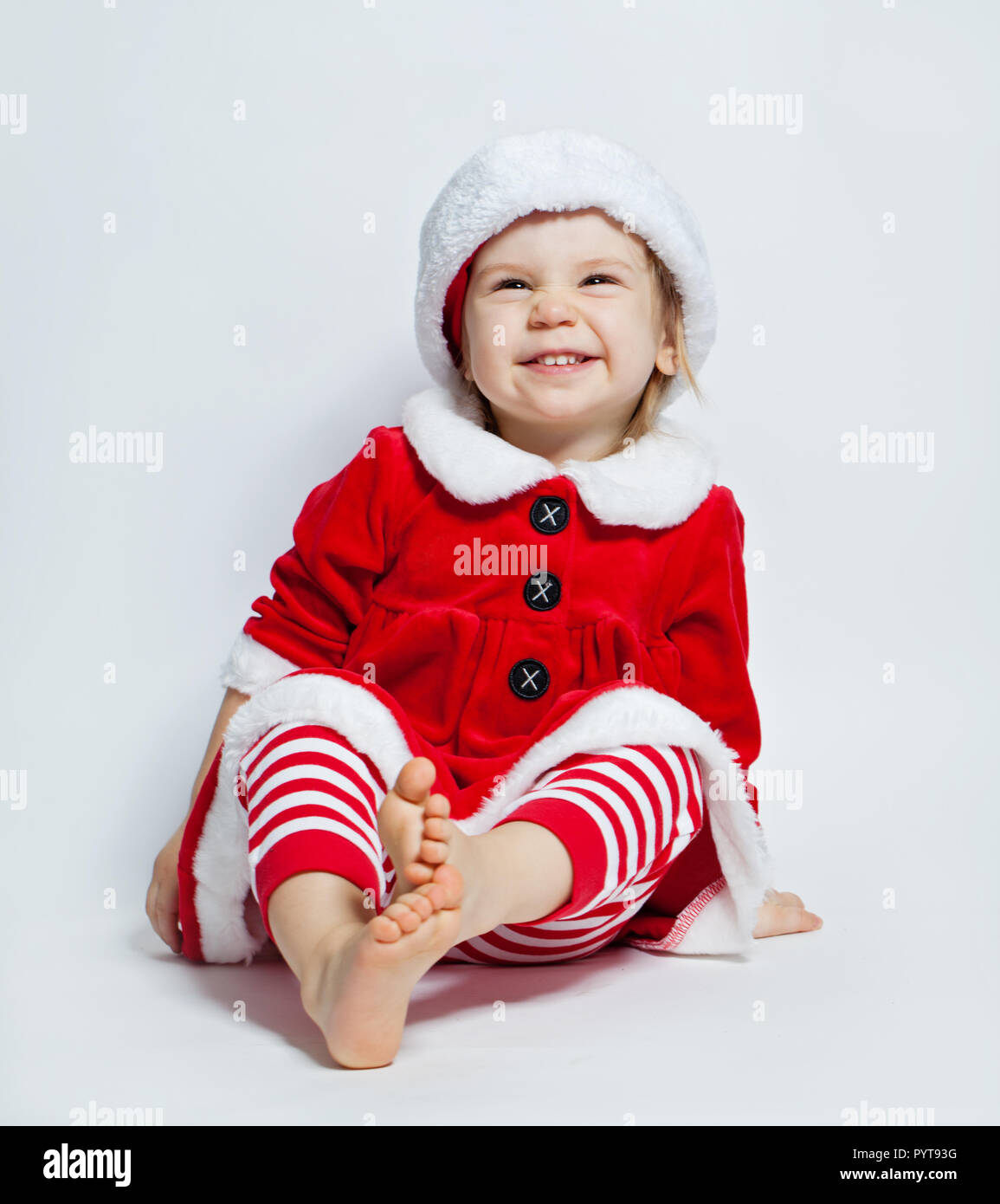 Christmas child wearing Santa hat sitting on white background Stock Photo