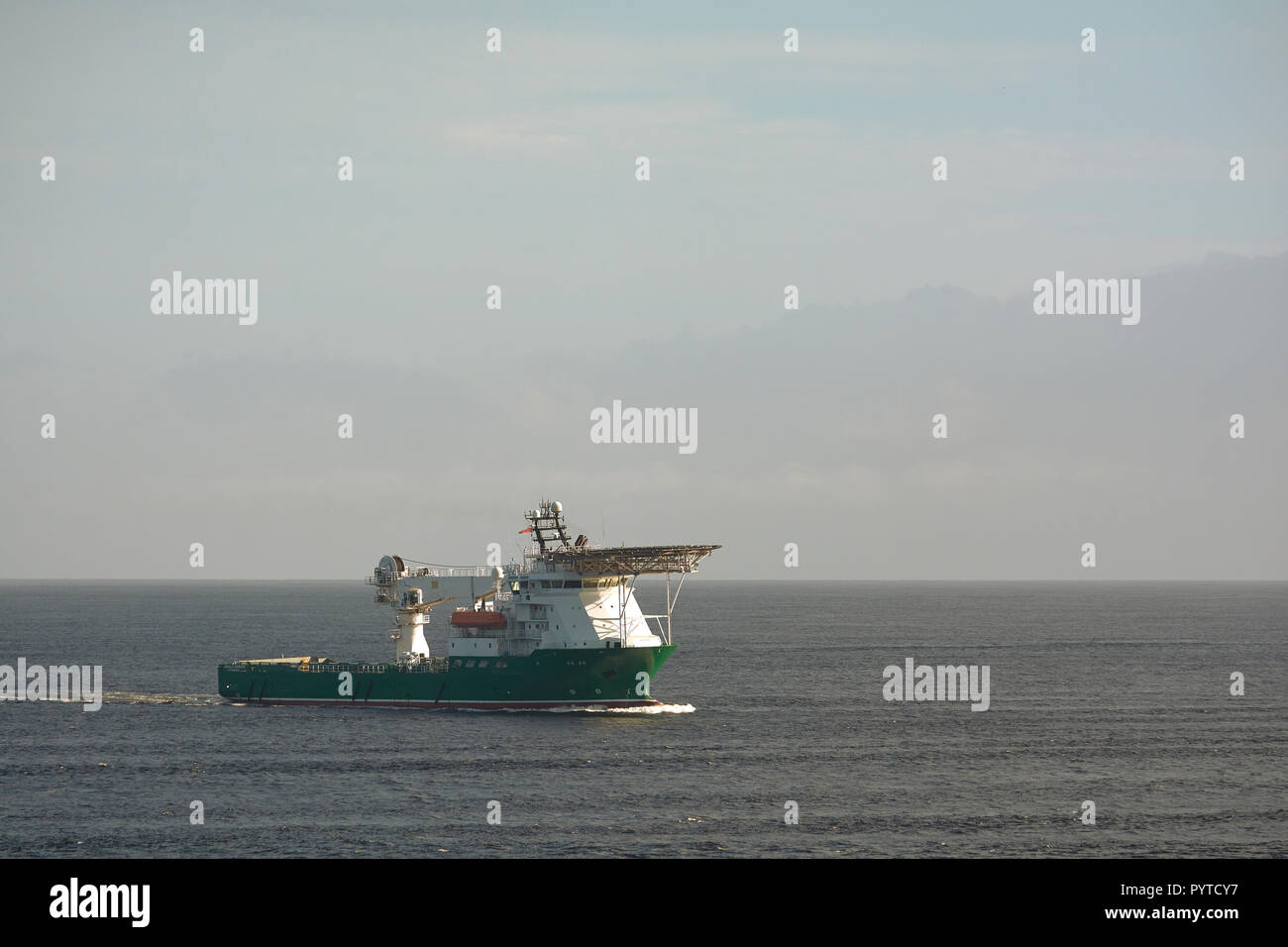 Offshore supply and diving support vessel working on a oil industry project  at sea, passing close to the coast of Trinidad and Tobago. Stock Photo