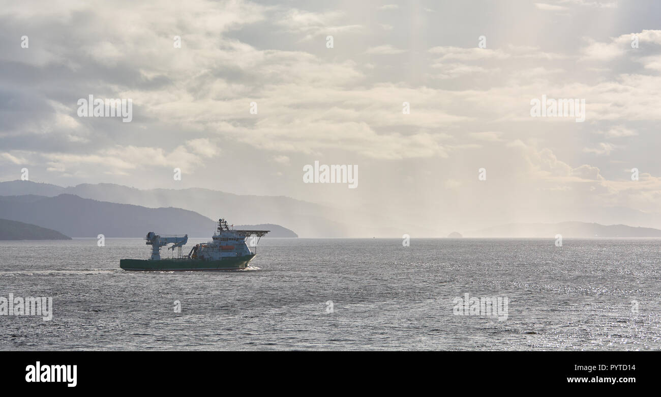 Offshore supply and diving support vessel working on a oil industry project  at sea, passing close to the coast of Trinidad and Tobago. Stock Photo