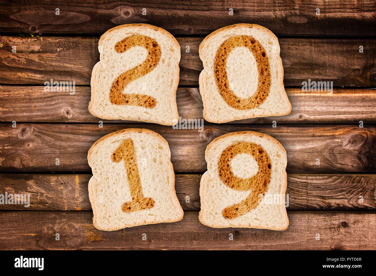 2019 greeting card toasted slices of bread on wooden planks background Stock Photo