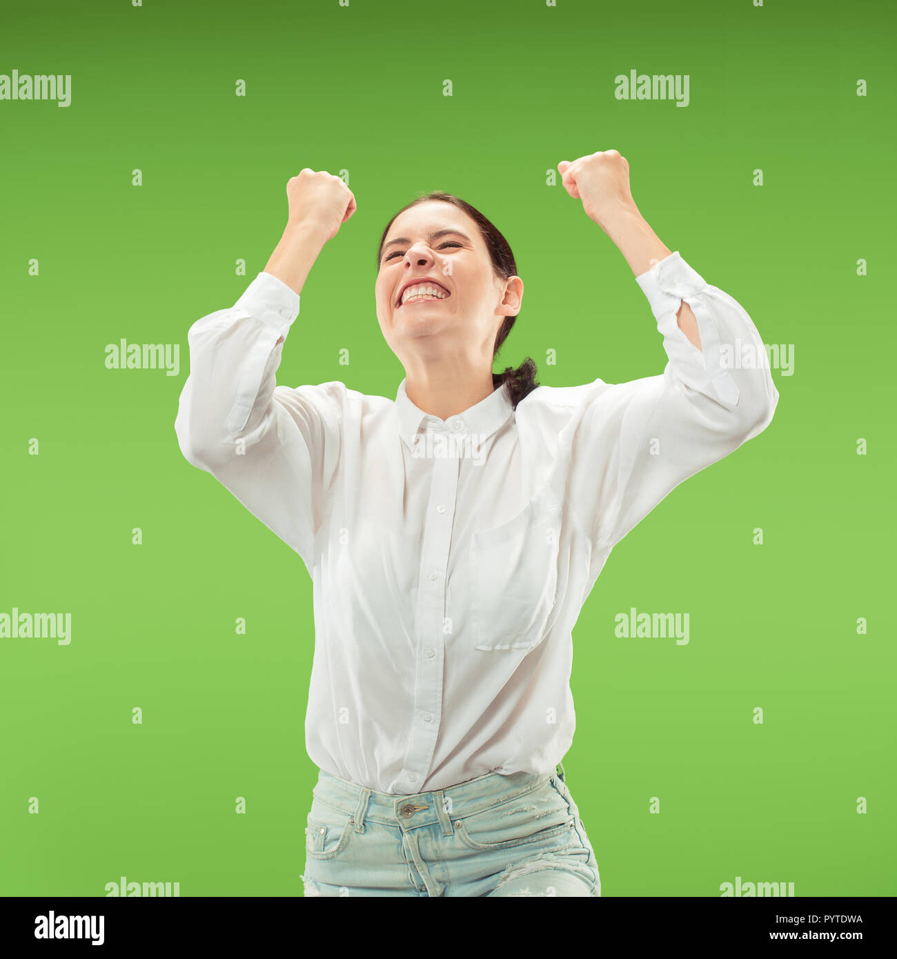 I won. Winning success happy woman celebrating being a winner. Dynamic image of caucasian female model on green studio background. Victory, delight concept. Human facial emotions concept. Trendy colors Stock Photo