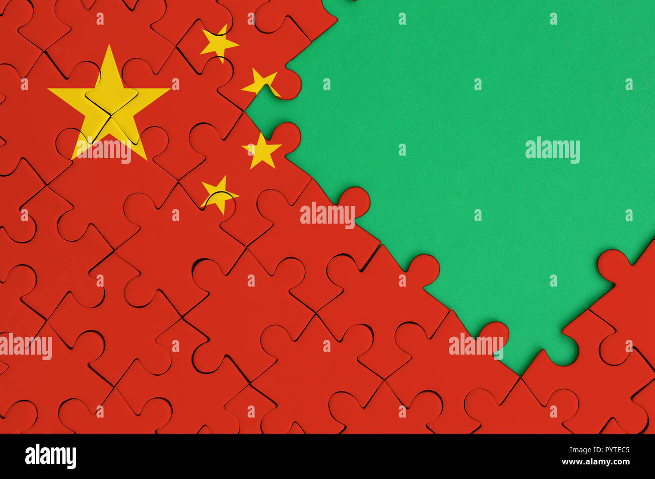 China flag  is depicted on a completed jigsaw puzzle with free green copy space on the right side. Stock Photo