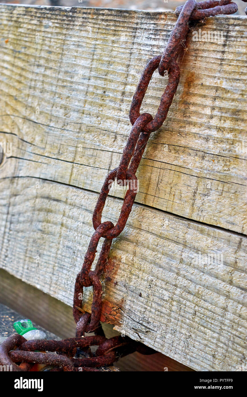 Rusty chain on timber beam Stock Photo