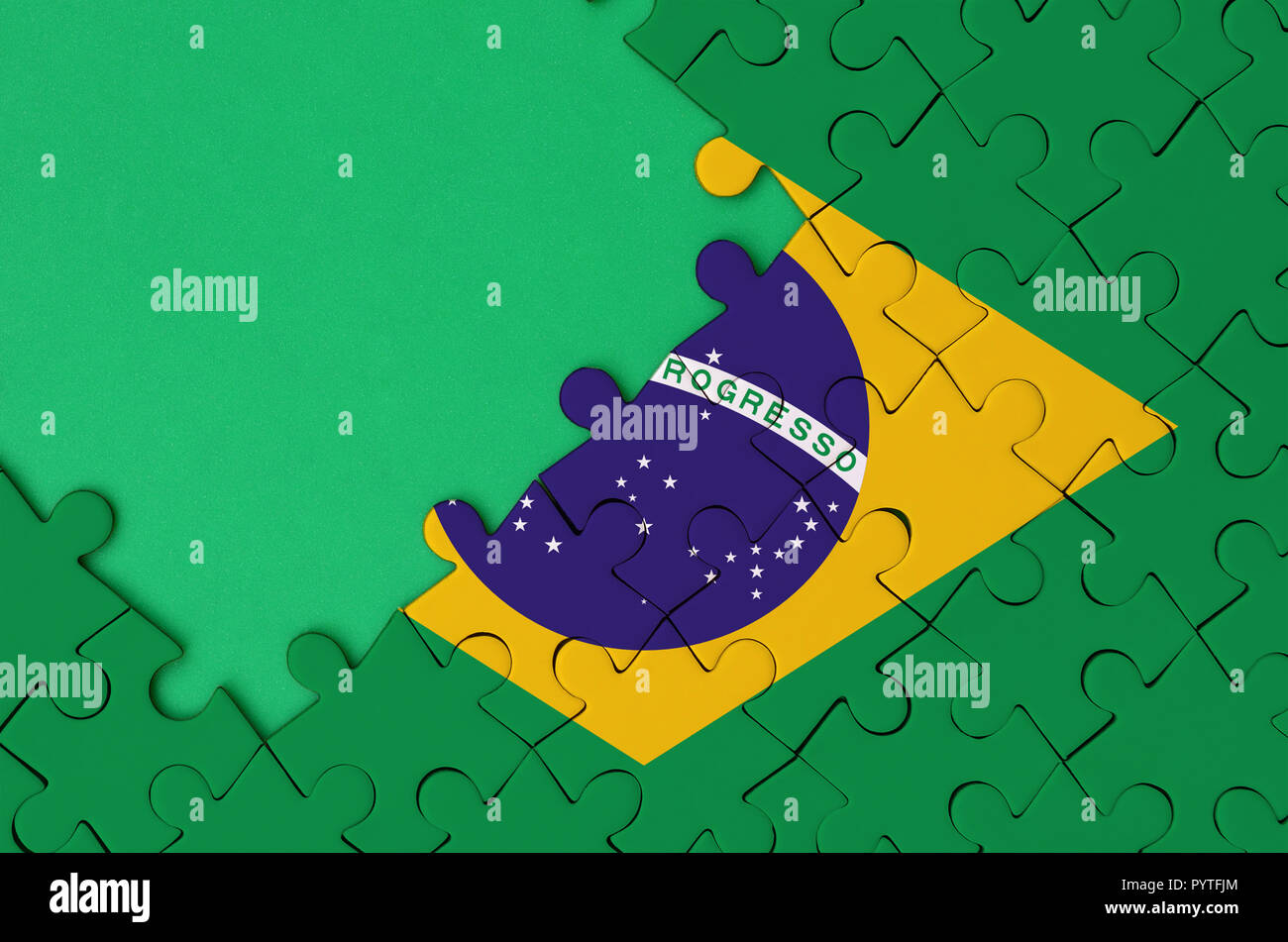 Brazil flag is depicted on a completed jigsaw puzzle with free green