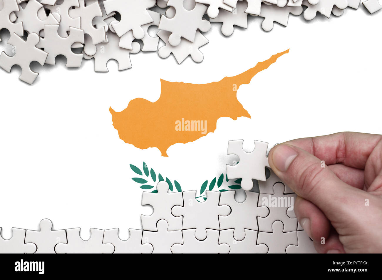 Cyprus flag is depicted on a table on which the human hand folds a ...