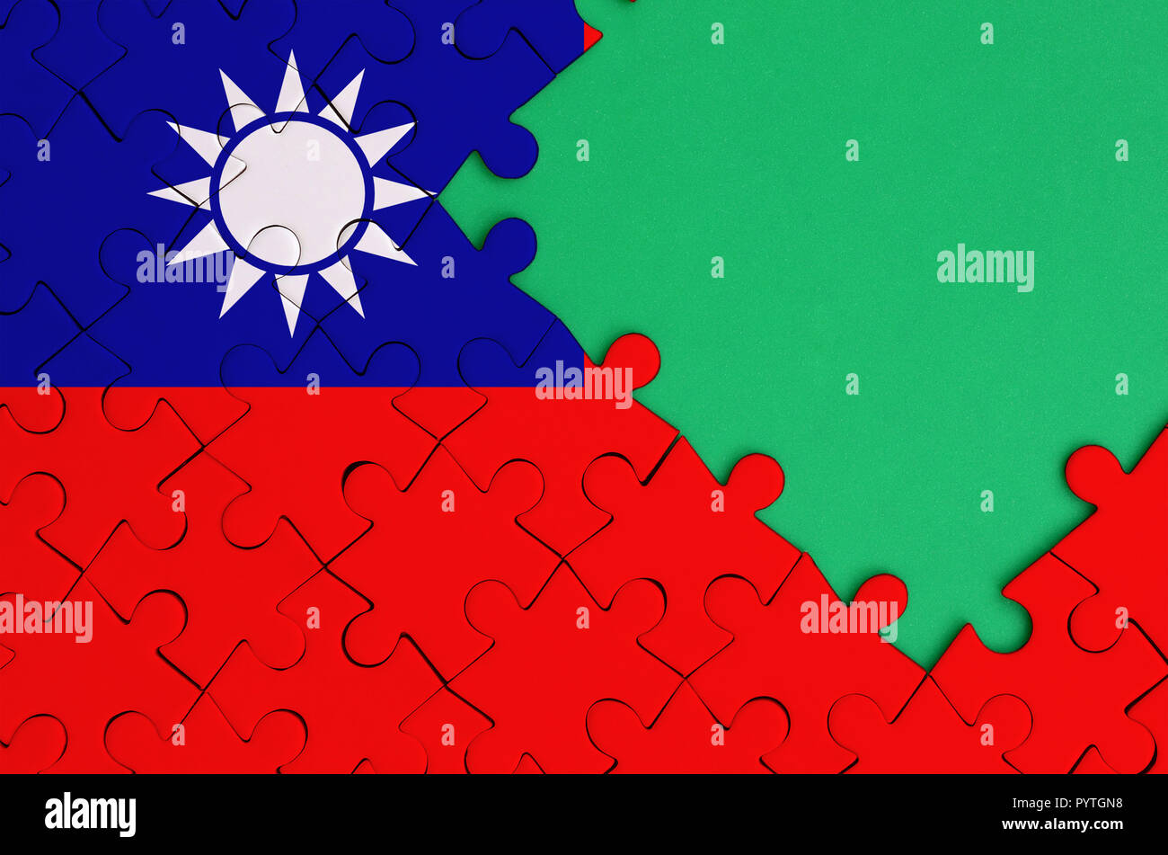 Taiwan flag  is depicted on a completed jigsaw puzzle with free green copy space on the right side. Stock Photo