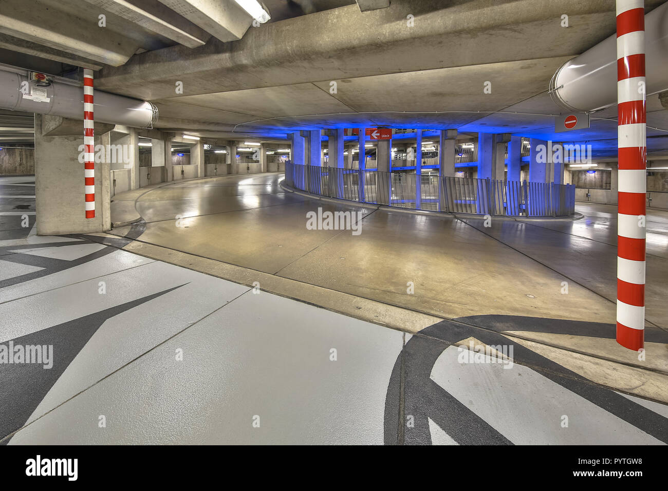 Empty ramp in circular underground parking garage with colorful lighting under a downtown shopping mall Stock Photo