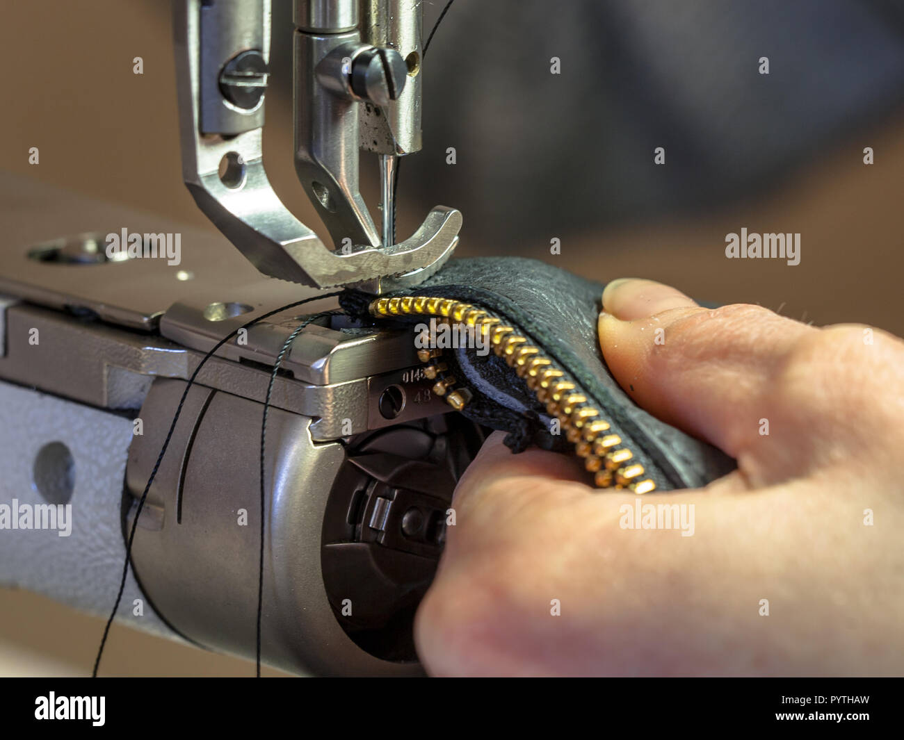 Leather sewing machine in action in a workshop with hands working on a  shoulder bag Stock Photo - Alamy