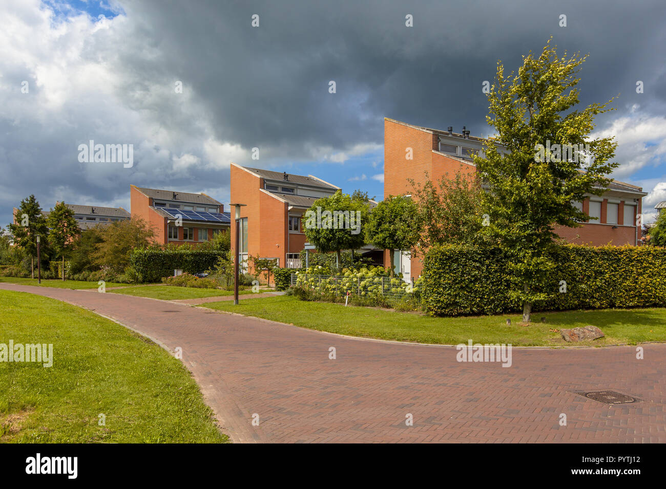Street with large detached houses with gardens in a suburb of Wageningen City, Netherlands Stock Photo
