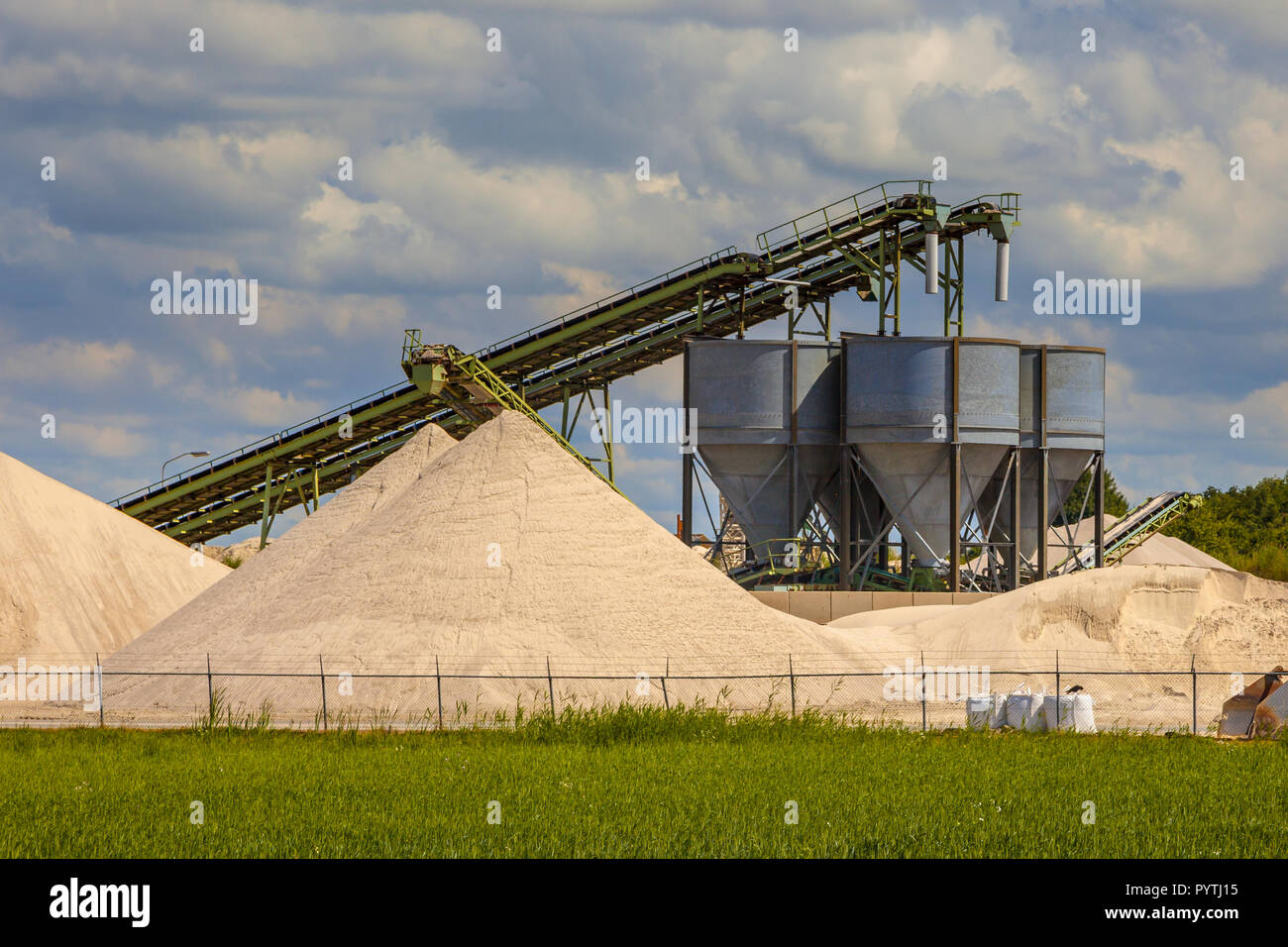 Industrial sand mining terminal with conveyer belts and silos on a summer day Stock Photo