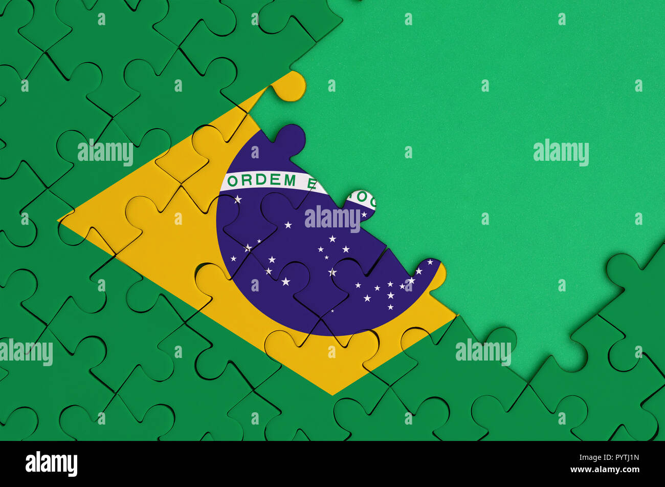 Brazil flag is depicted on a completed jigsaw puzzle with free green