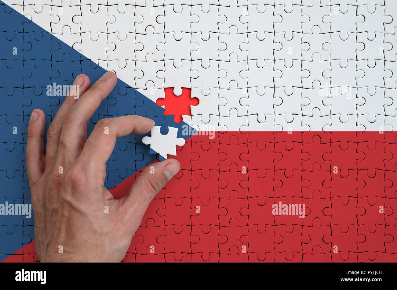 Czech flag is depicted on a puzzle, which the man's hand completes to ...