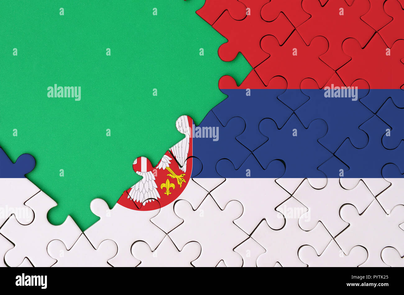 Serbia flag is depicted on a completed jigsaw puzzle with free green ...