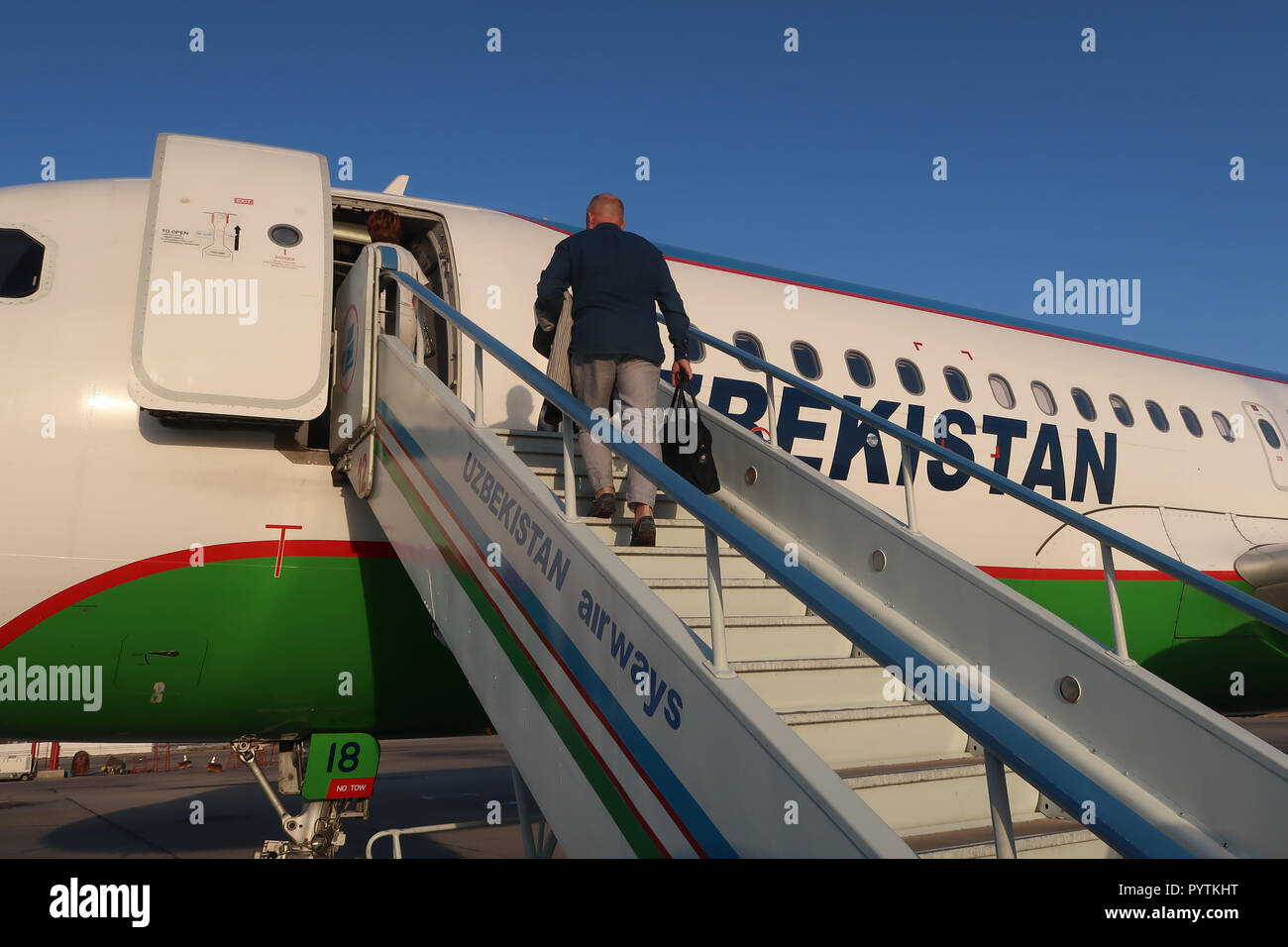 A passenger embarks an airplane of National Air Company Uzbekistan Airways at Tashkent Yuzhny International Airport Uzbekistan Stock Photo