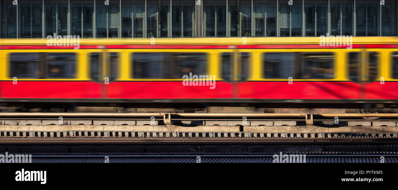 Blur yellow red train in motion, office building background Stock Photo