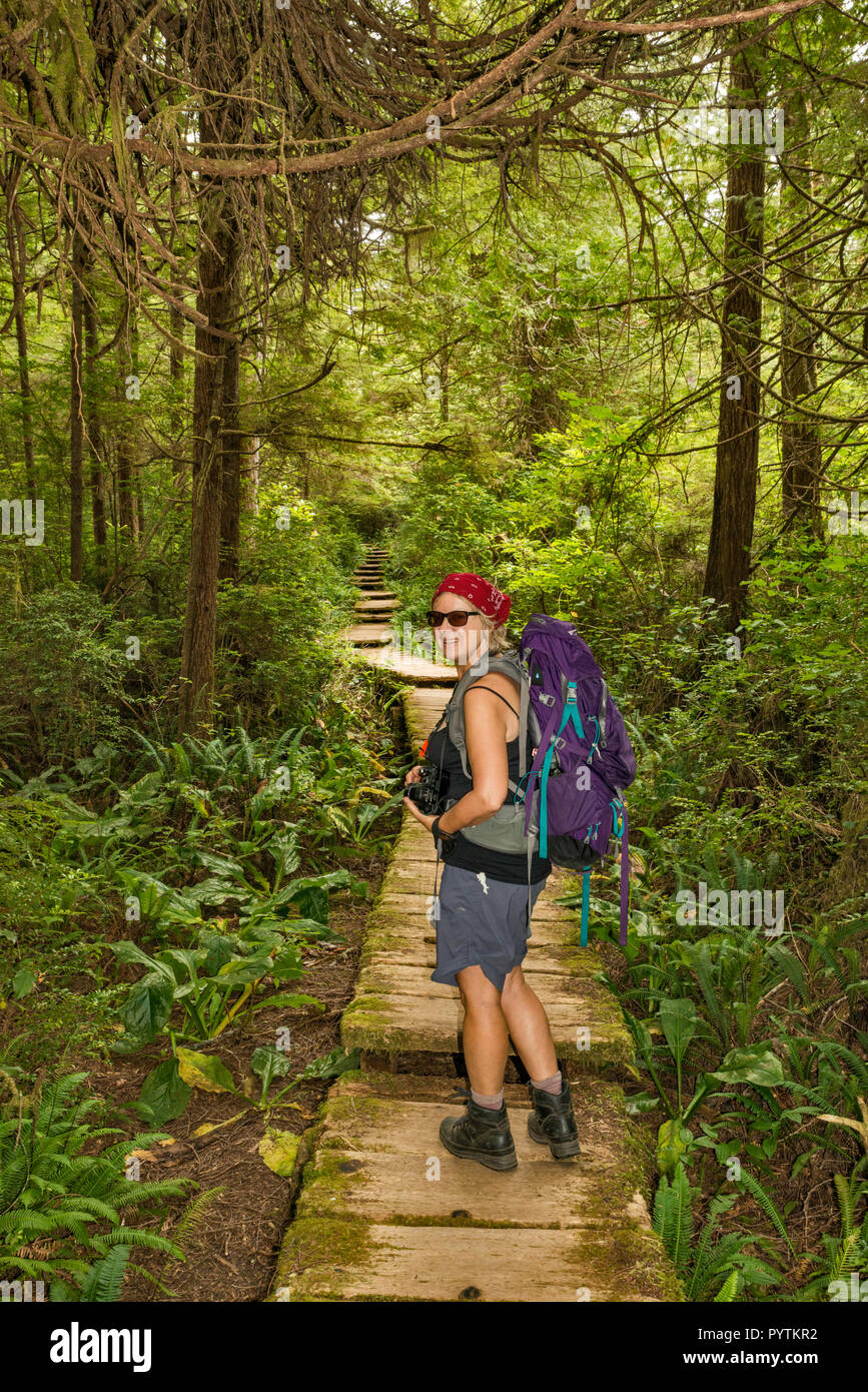 Middle age woman hiking, Cape Alava Trail, temperate rain forest, near Cape Alava, Pacific Coast, Olympic National Park, Washington state, USA Stock Photo