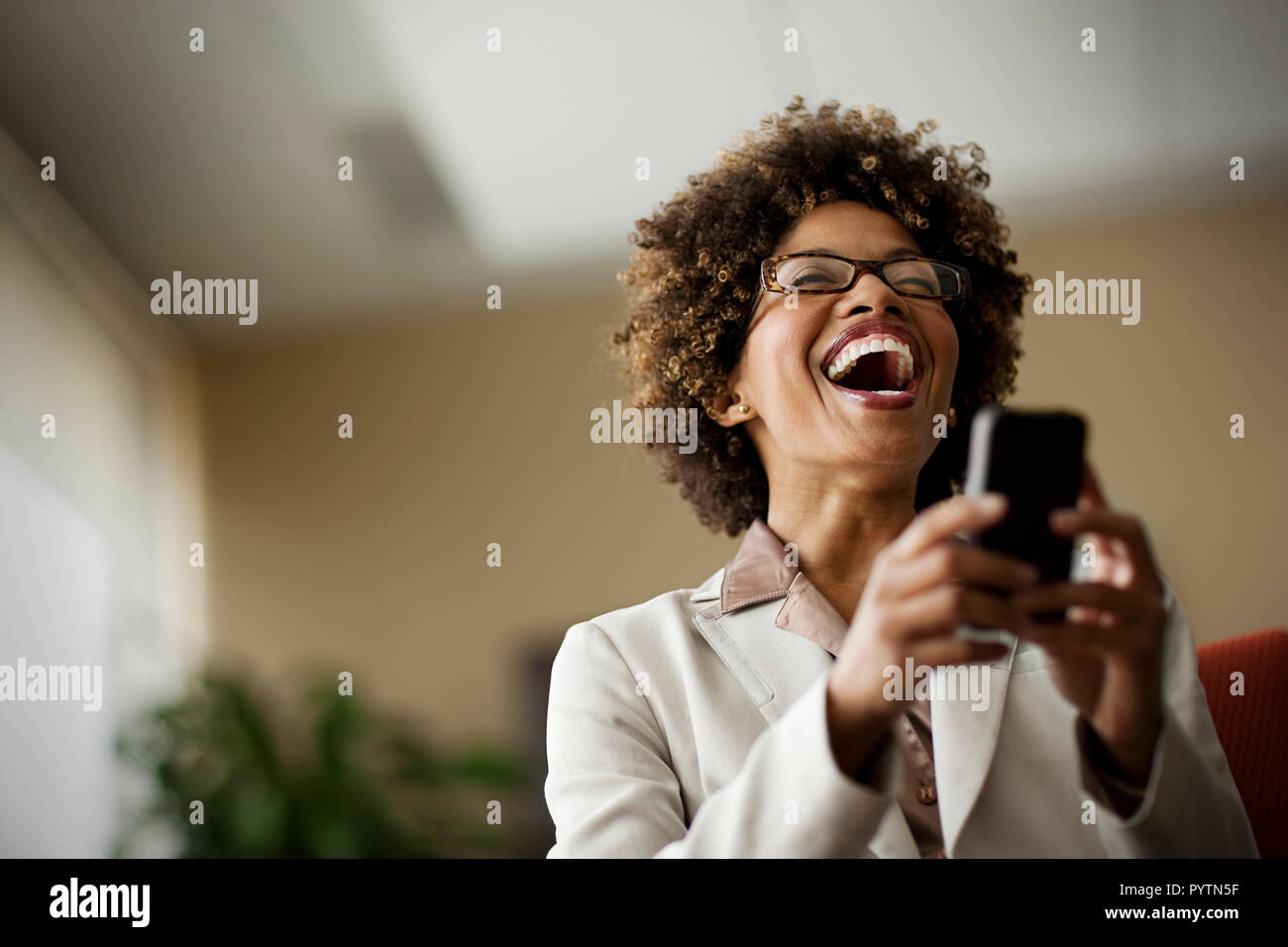 African woman laughing text message hi-res stock photography and images ...