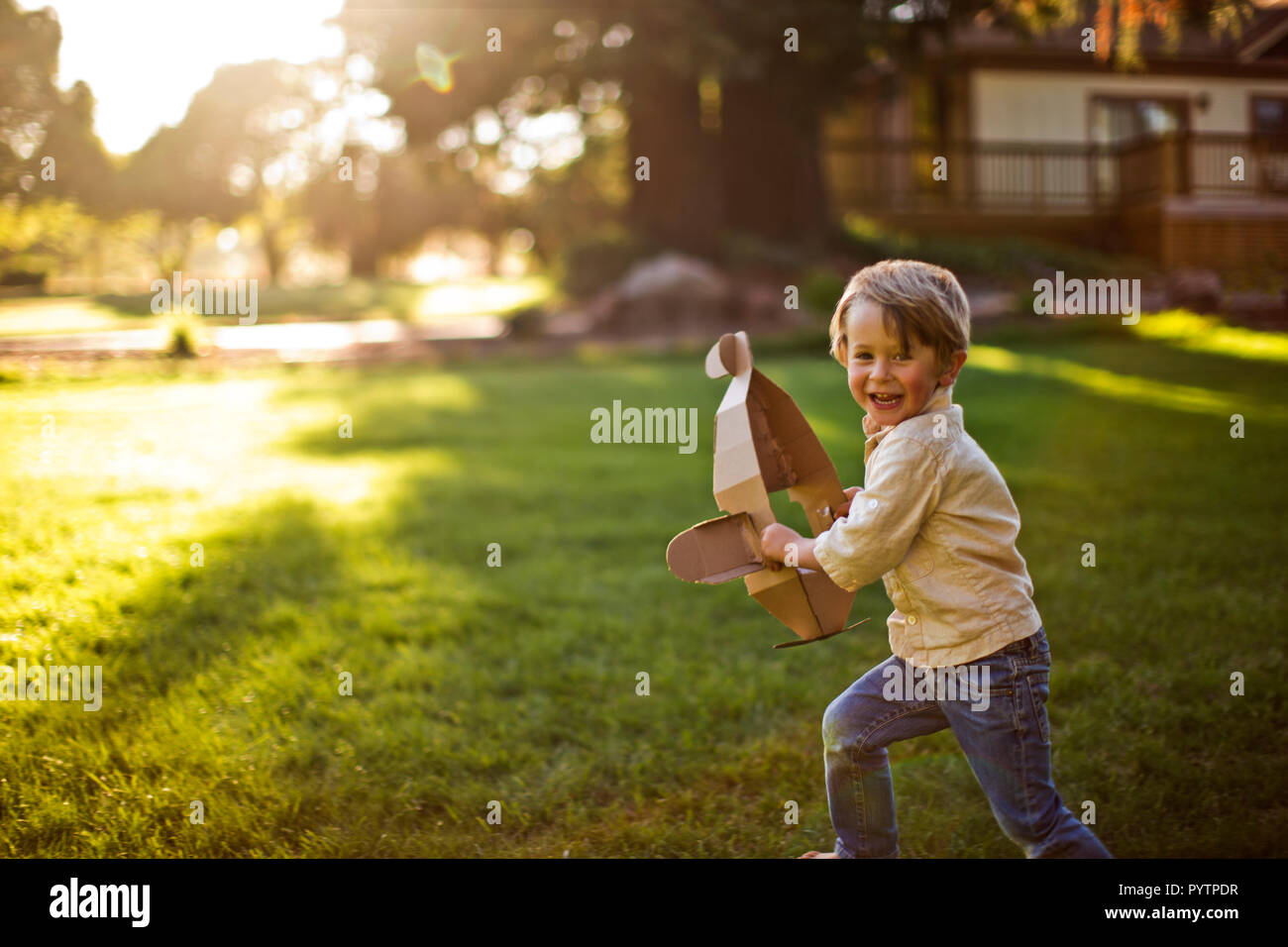 Happy young boy playing with a toy plane Stock Photo - Alamy