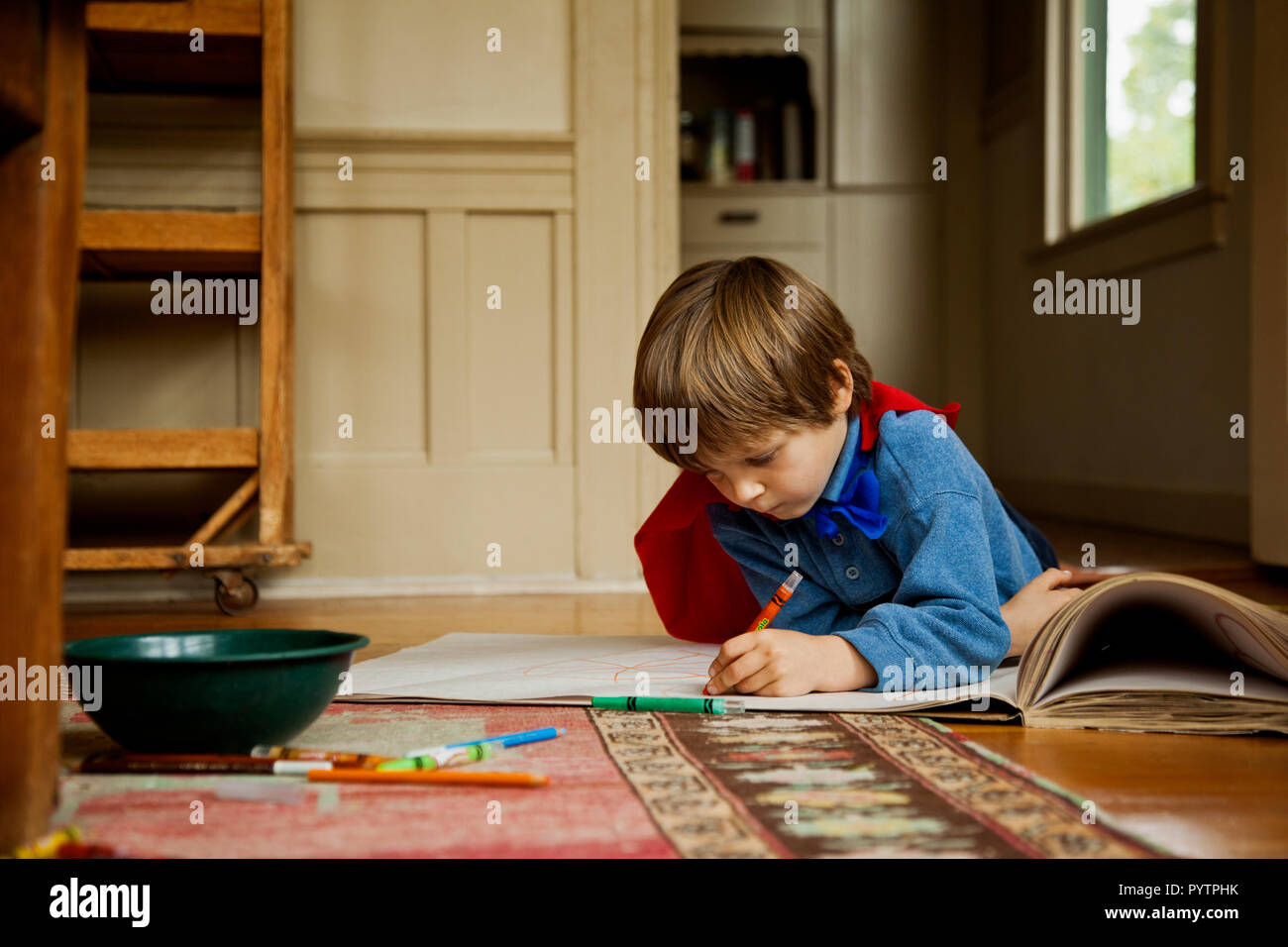 Young boy intently coloring in with crayons. Stock Photo