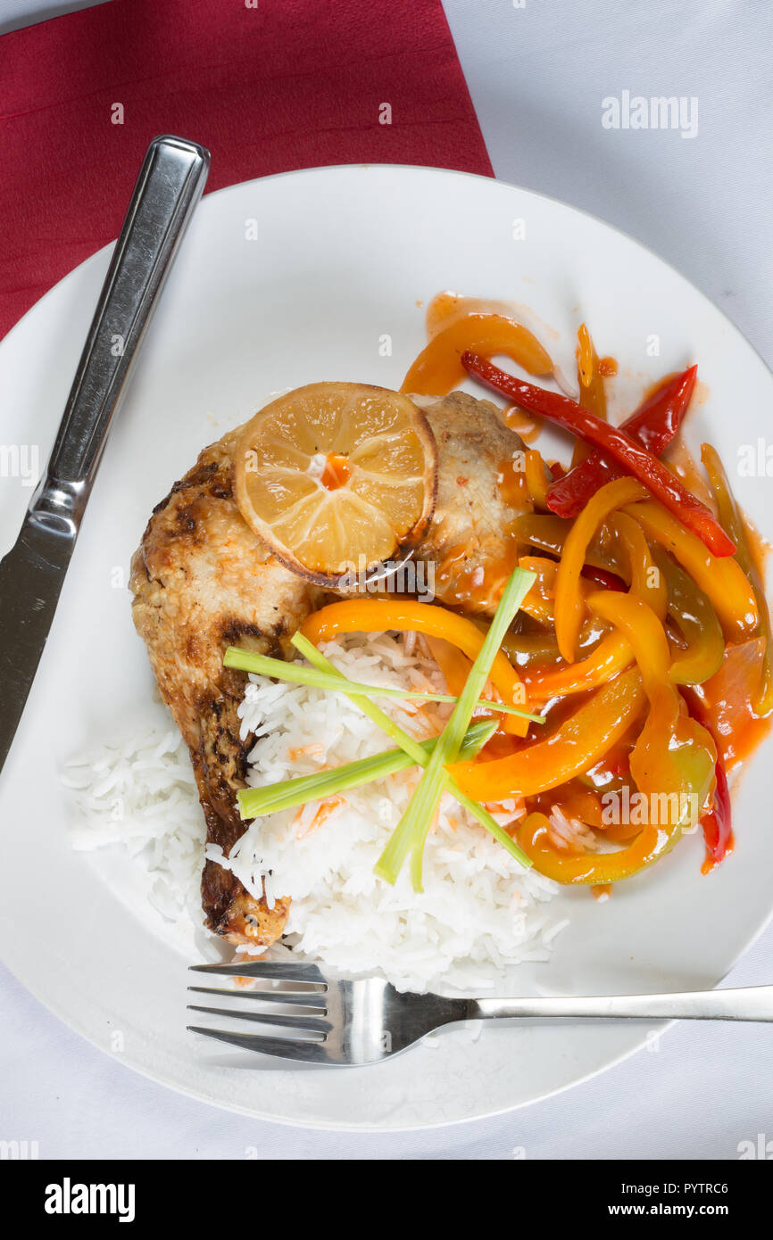 An English pub/restaurant main course dish of Roasted Chicken leg with boiled white rice and