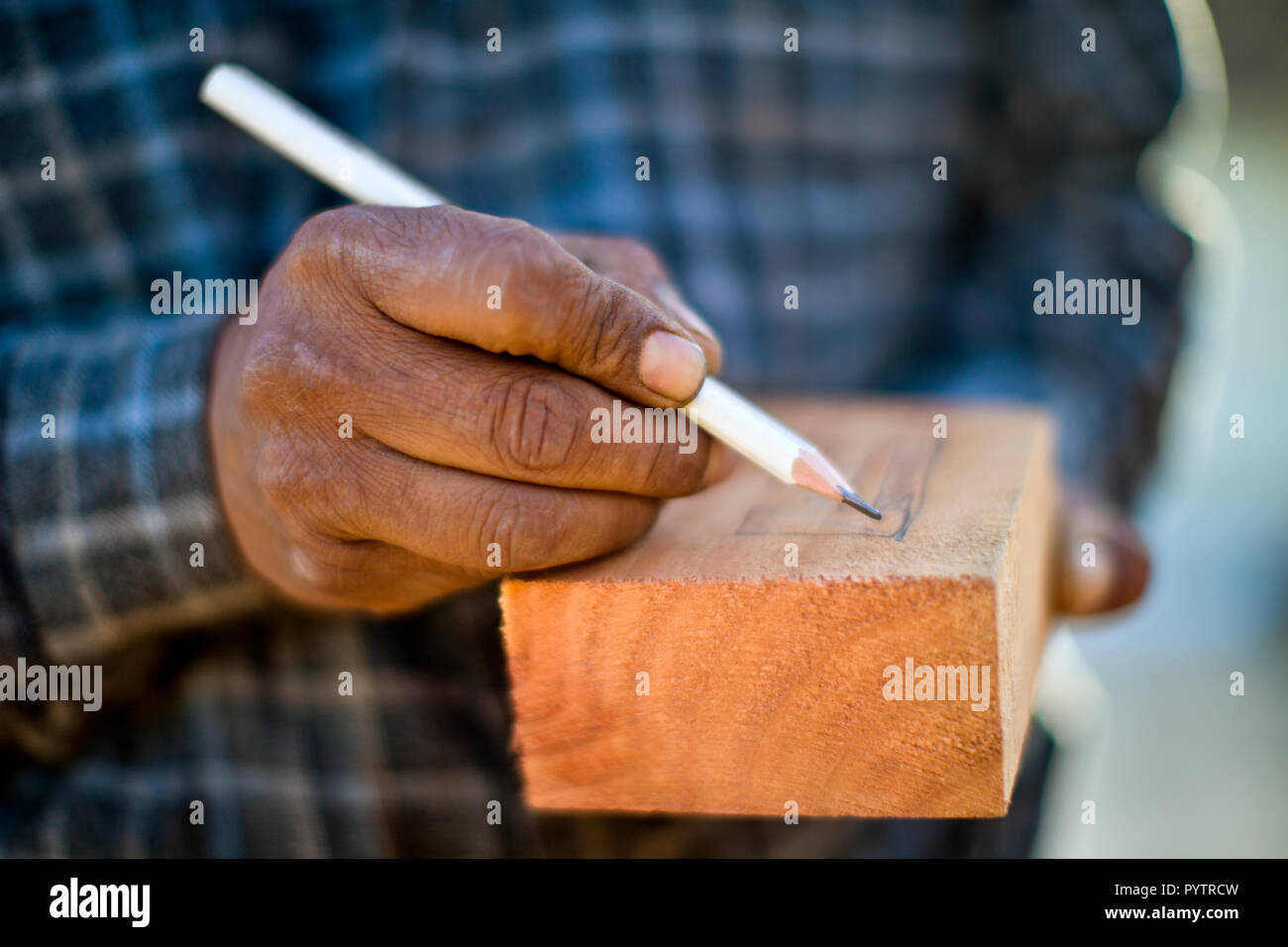 Builder cutting a piece of wood with a circular saw. Stock Photo