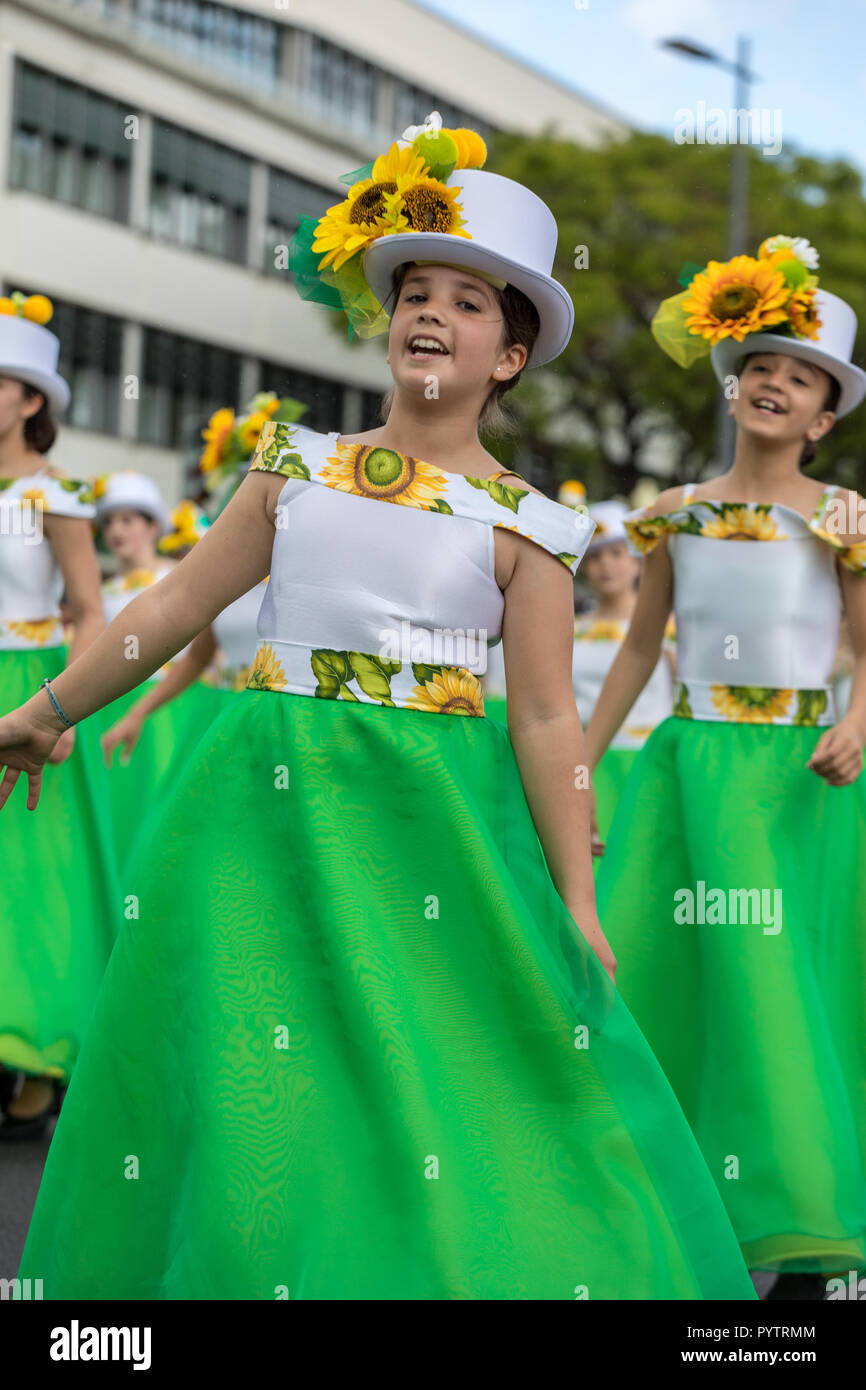 Funchal; Madeira; Portugal - April 22; 2018: A group of girls in colorful dresses with sunflowers motifs are dancing at Madeira Flower Festival Parade Stock Photo