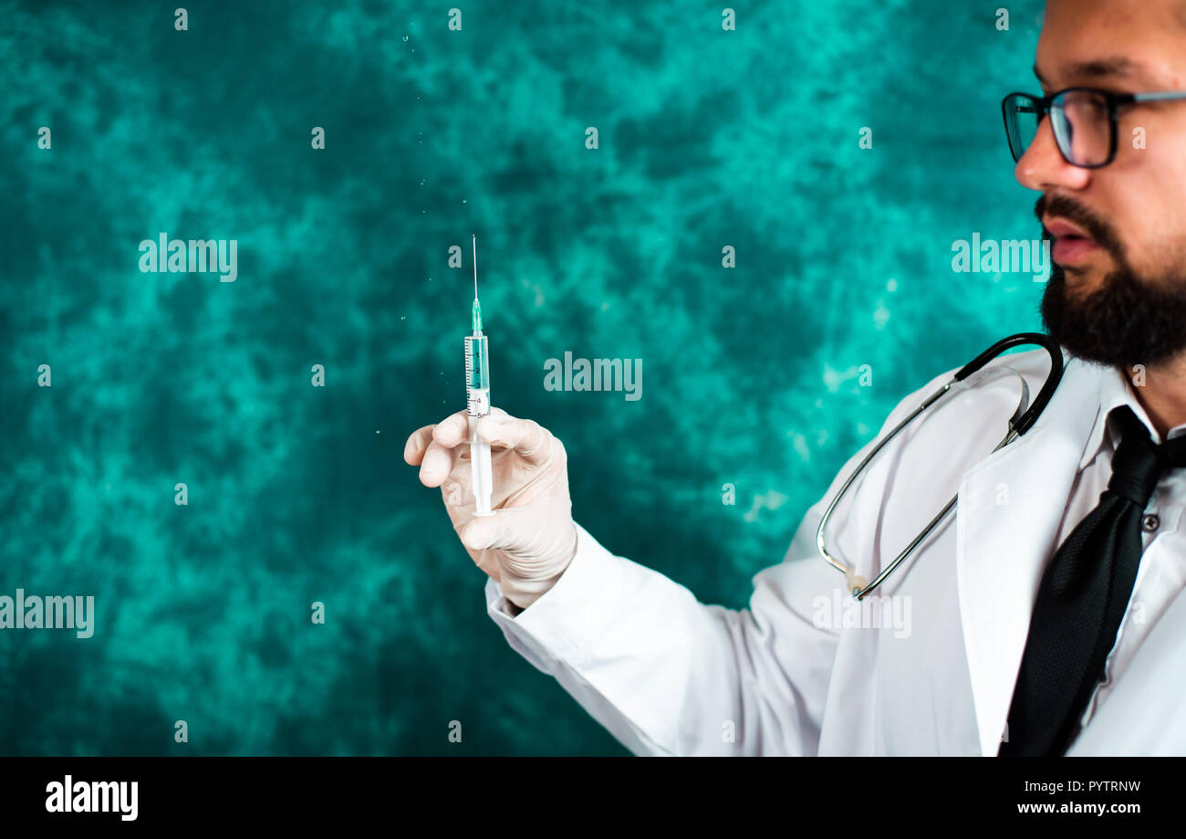 Handsome doctor holding a syringe close up portrait Stock Photo