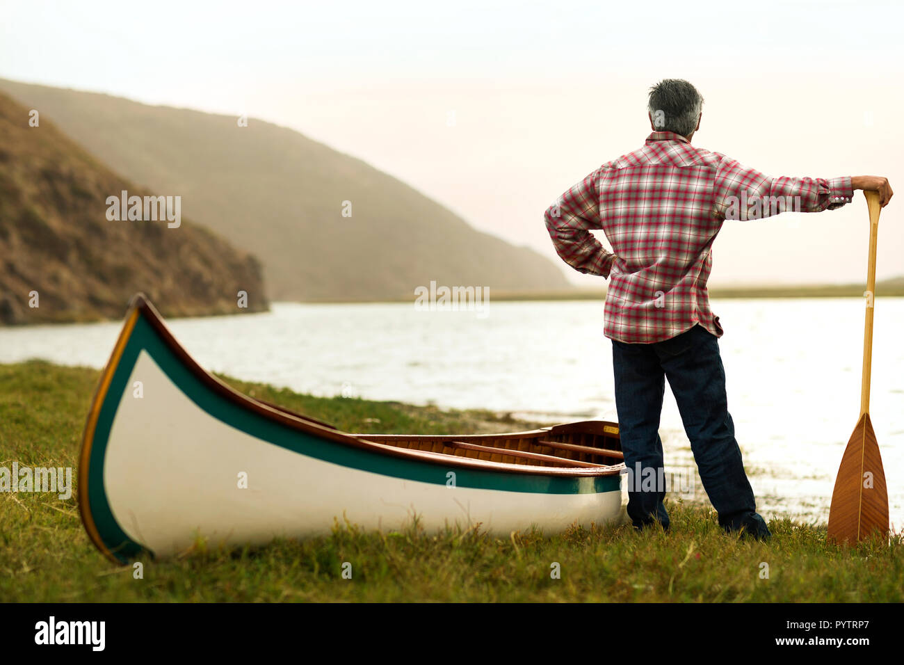Man looks out a at lake view before canoeing. Stock Photo